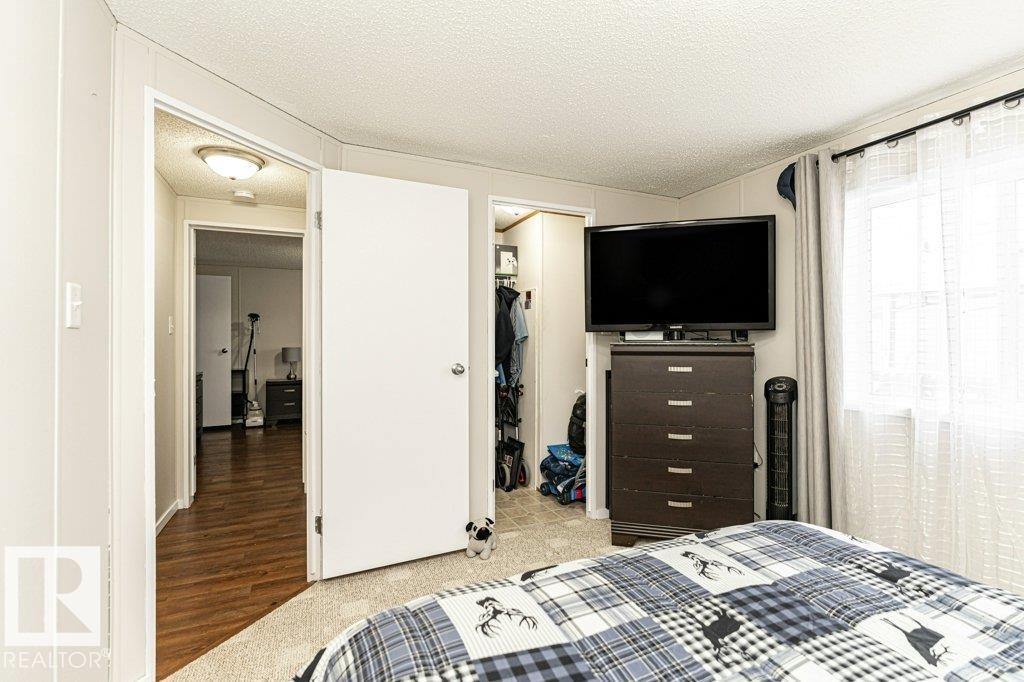 Bedroom featuring light carpeting, a white paneled ceiling, and a window with sheer and solid curtains - 1637 68 Avenue, Edmonton, AB - Indoor Photo Showing Bedroom
