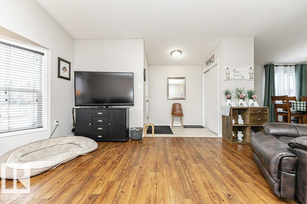 Spacious interior featuring wood-finish flooring, a large window with blinds, and light neutral wall finishes - 1637 68 Avenue, Edmonton, AB - Indoor Photo Showing Living Room