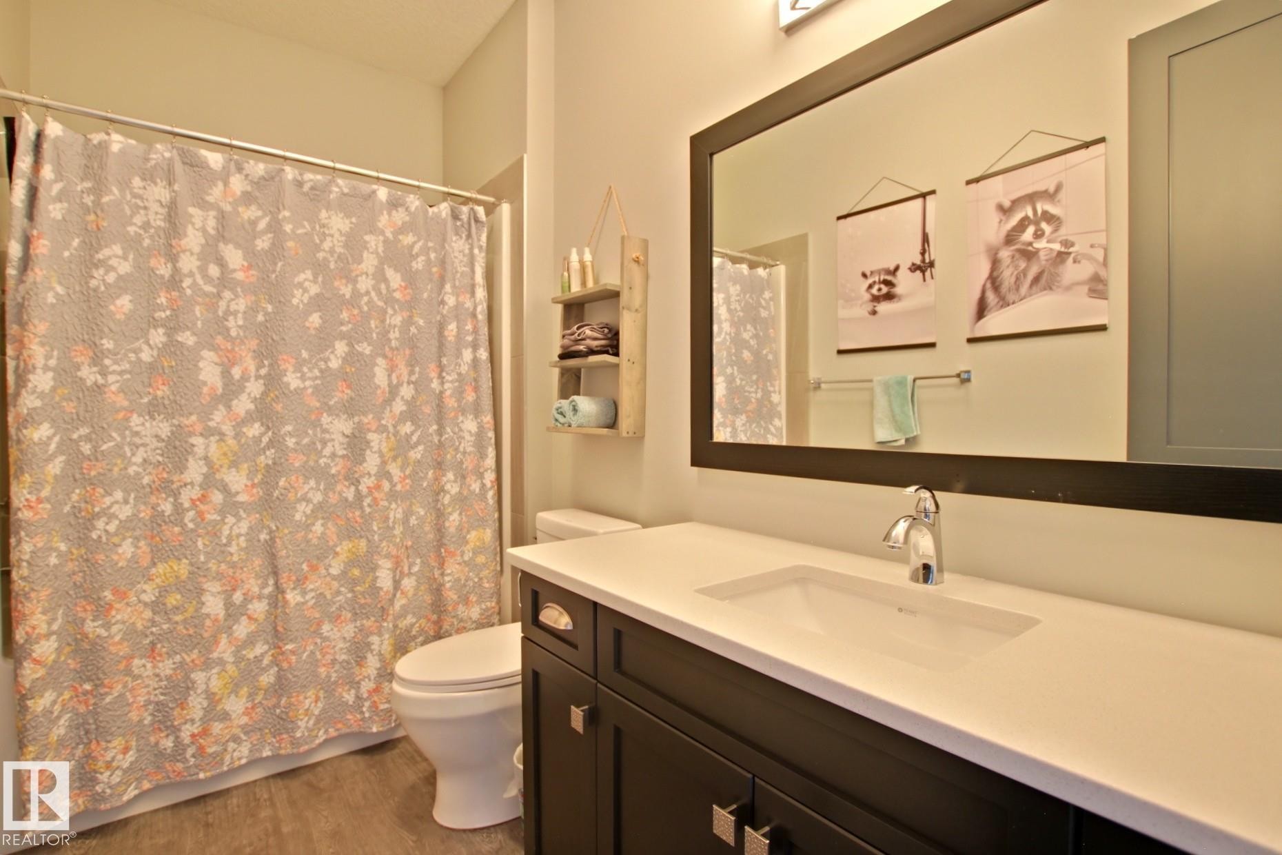 Bathroom featuring a dark wood vanity with a white countertop and integrated sink - 9711 223 Street, Edmonton, AB