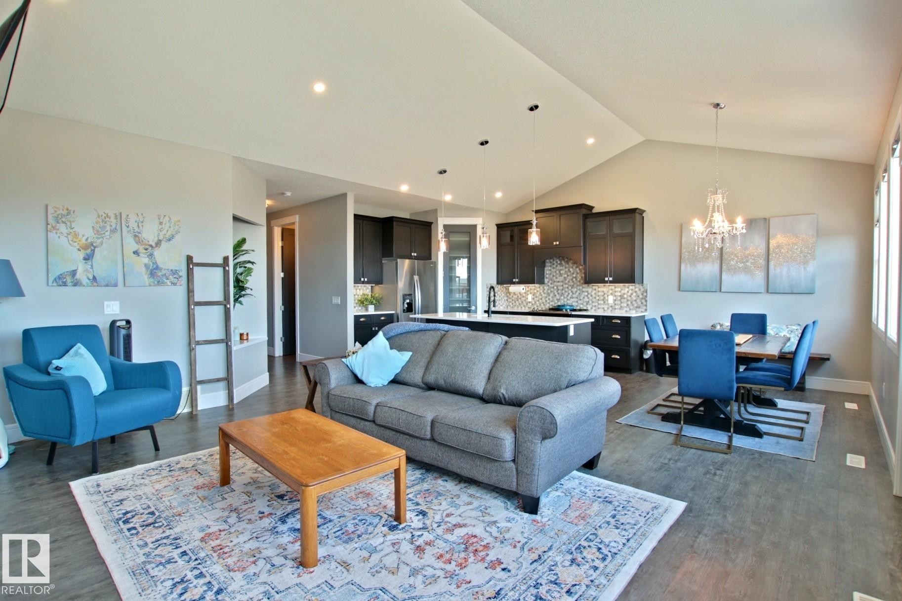 Open-concept living space featuring wood-finish flooring, recessed lighting, and a vaulted ceiling - 9711 223 Street, Edmonton, AB
