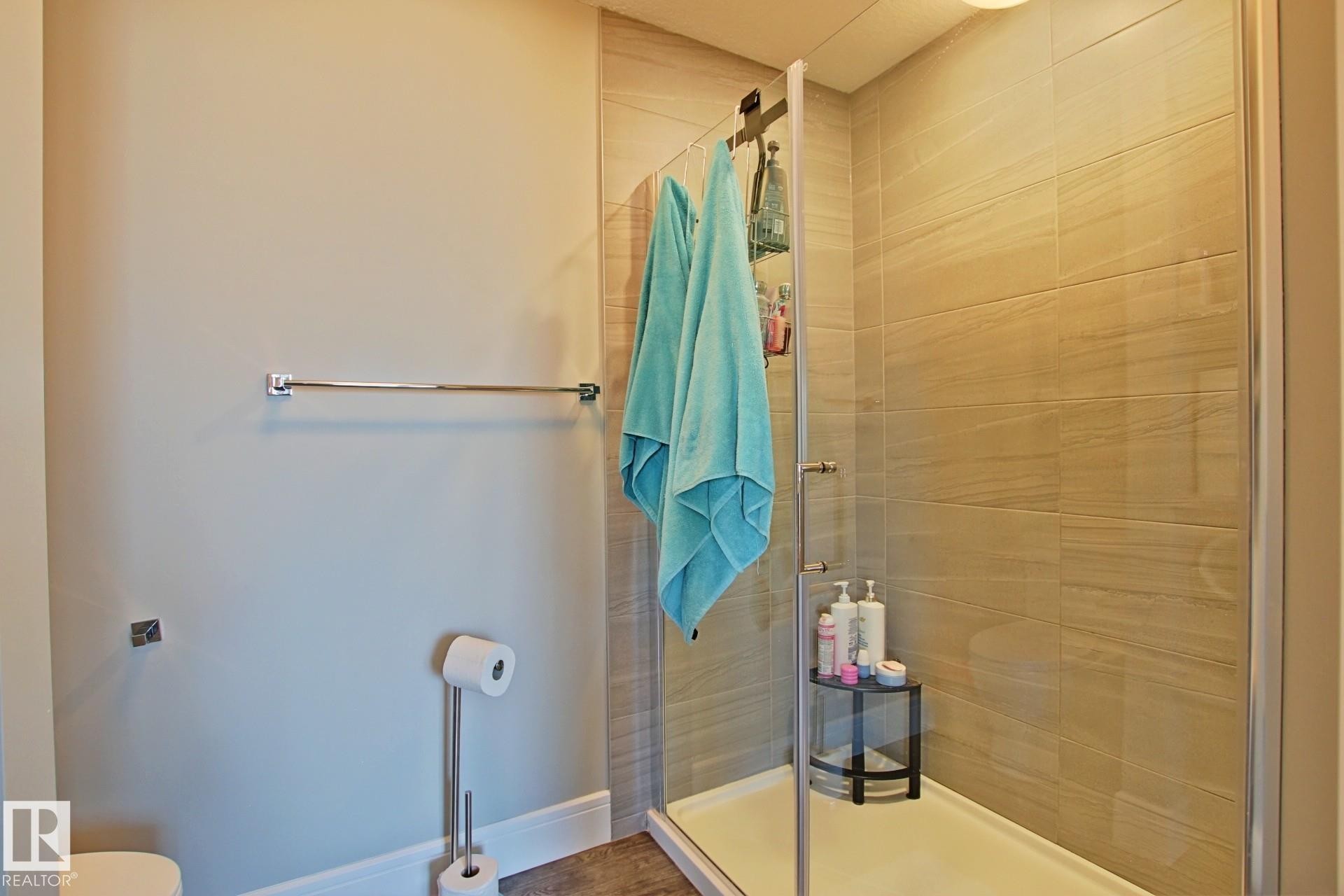 Walk-in shower with clear glass enclosure and light-toned tile surround - 9711 223 Street, Edmonton, AB
