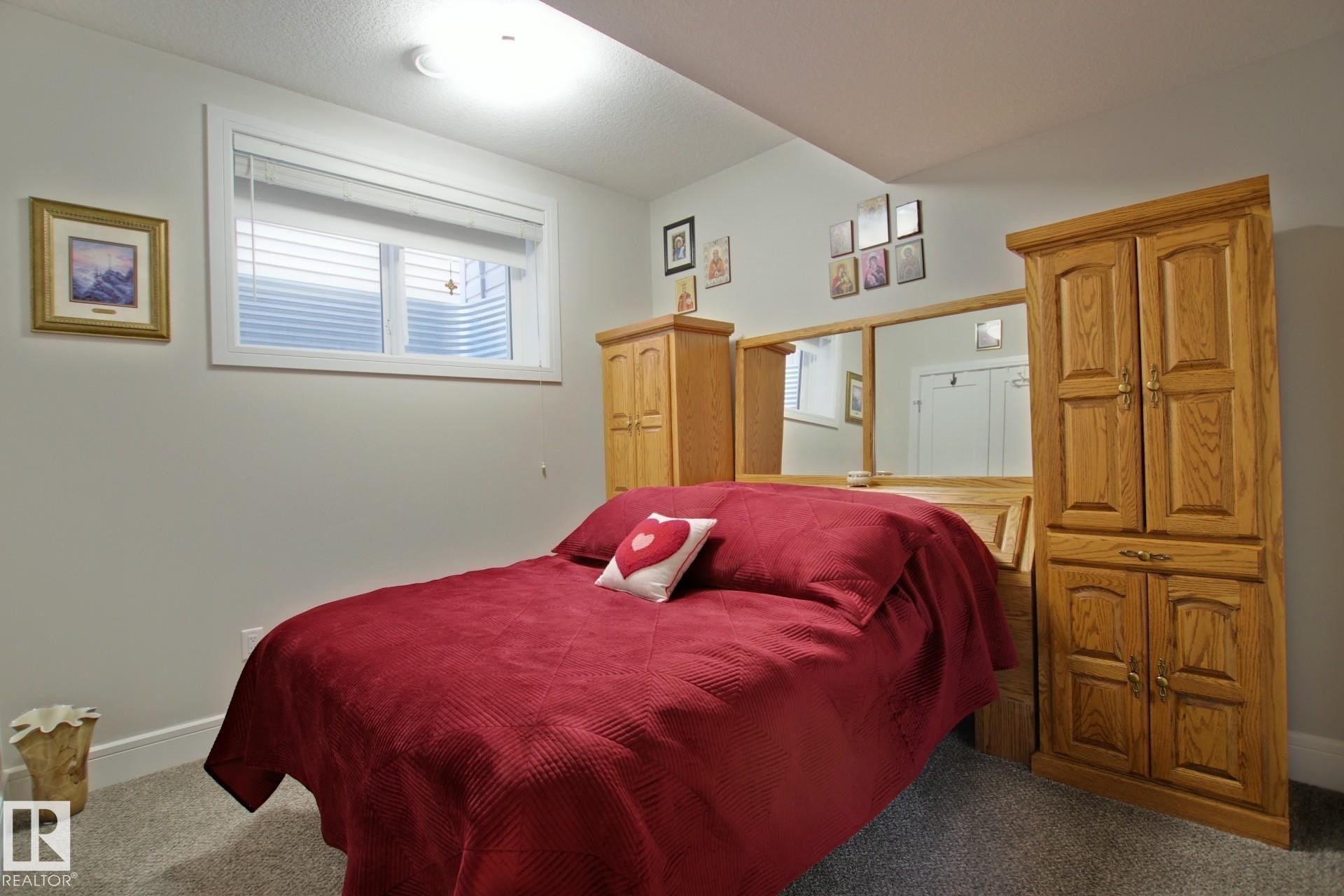 Bedroom featuring a perimeter window, light gray wall paint, and gray carpet flooring - 9711 223 Street, Edmonton, AB