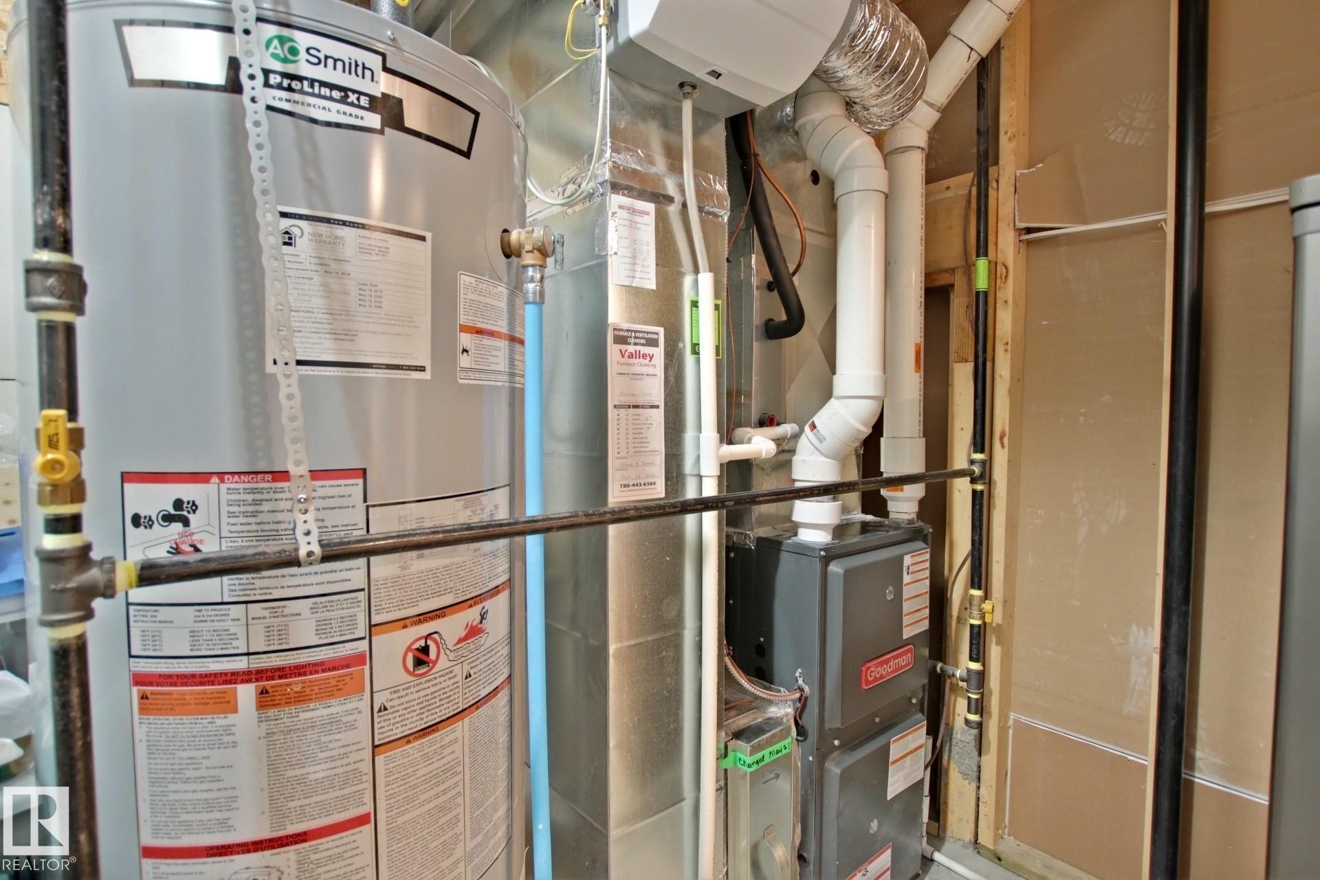 Utility area featuring a water heater, furnace, and exposed piping - 9711 223 Street, Edmonton, AB