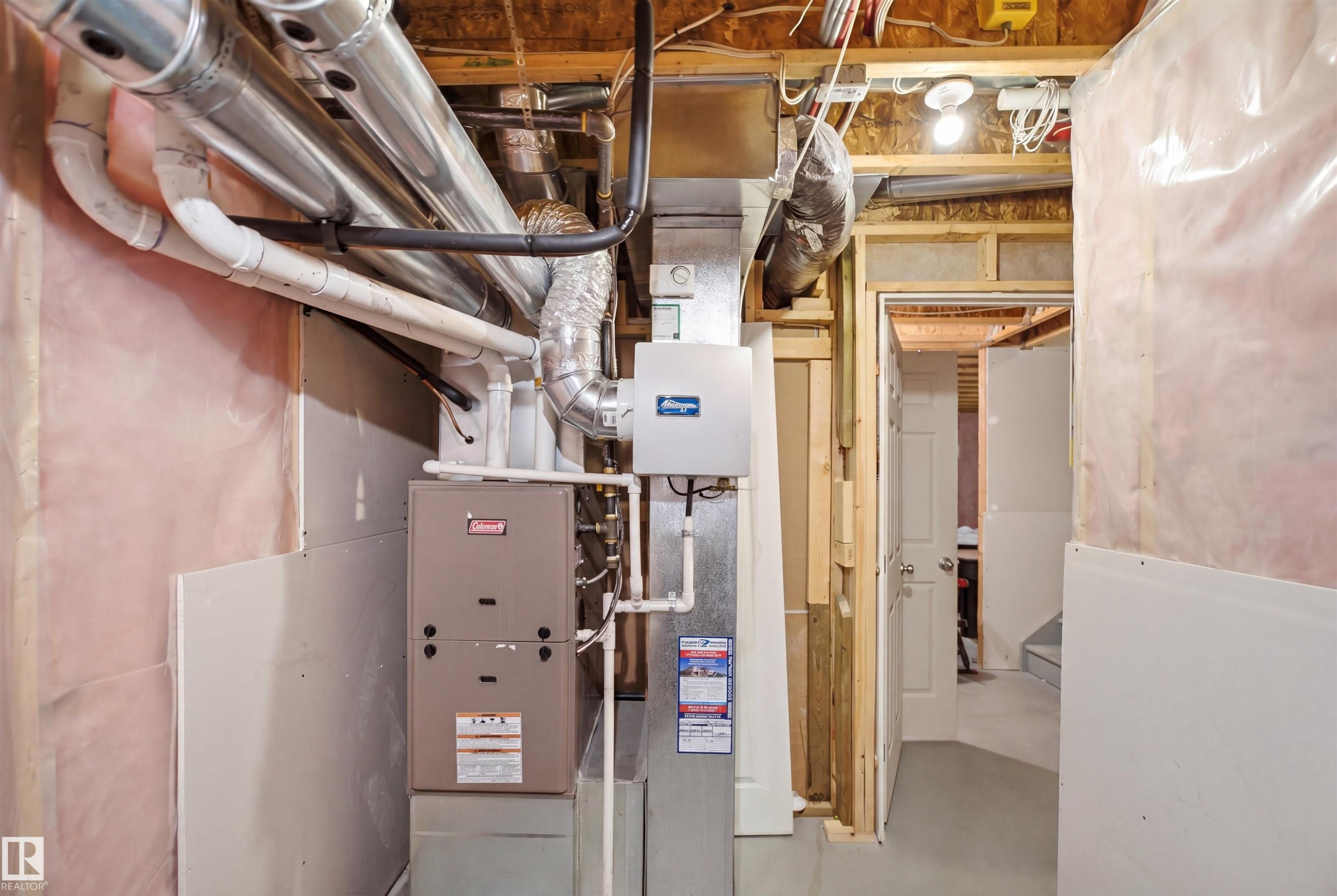 Utility room featuring a furnace system, water heater, exposed ductwork, and unfinished wall insulation - 7323 24 Ave, Edmonton, AB - Indoor Photo Showing Basement