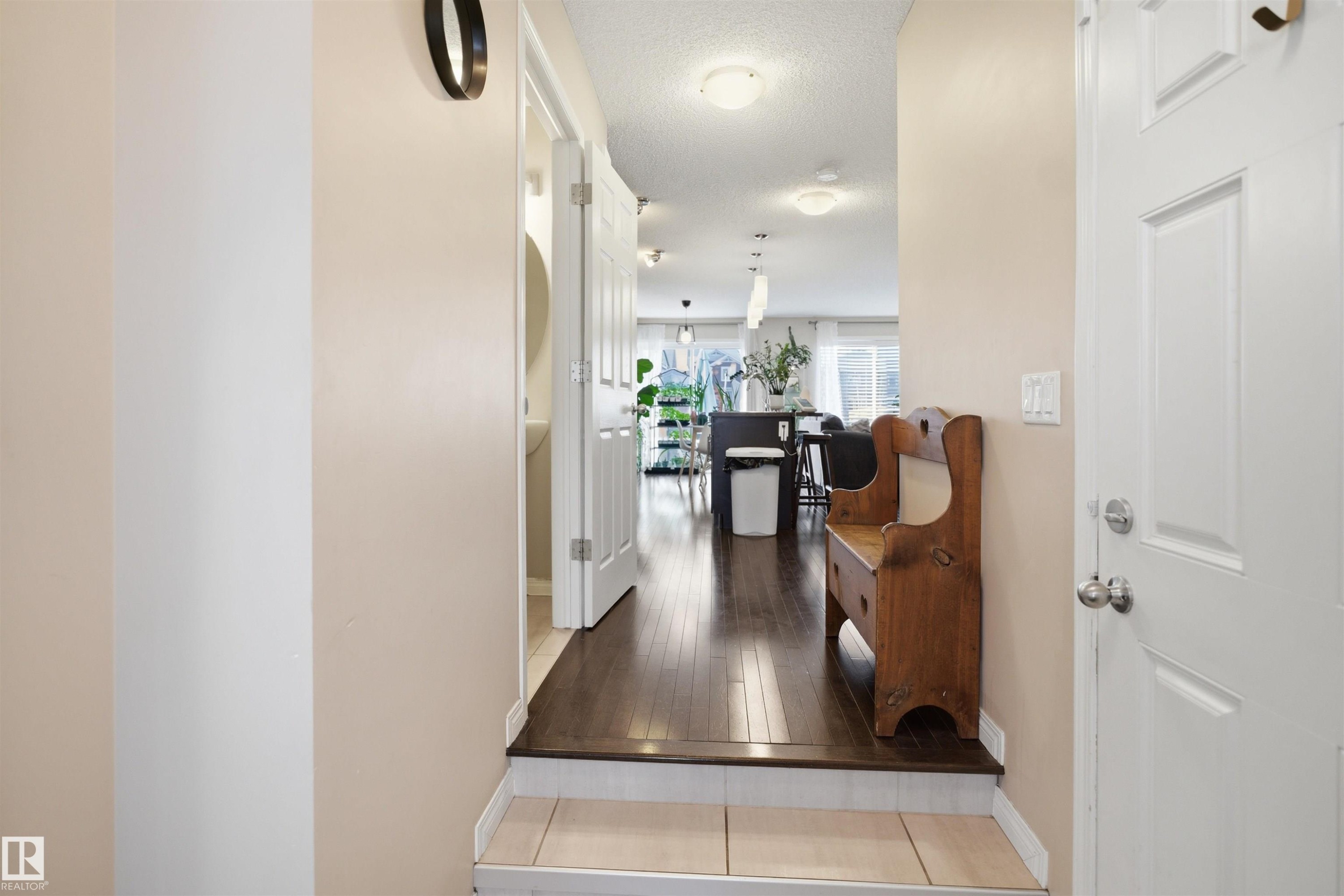 Entryway with light-toned wall finishes, tile flooring, and wood-finish flooring extending into the interior - 7323 24 Ave, Edmonton, AB - Outdoor With Deck Patio Veranda
