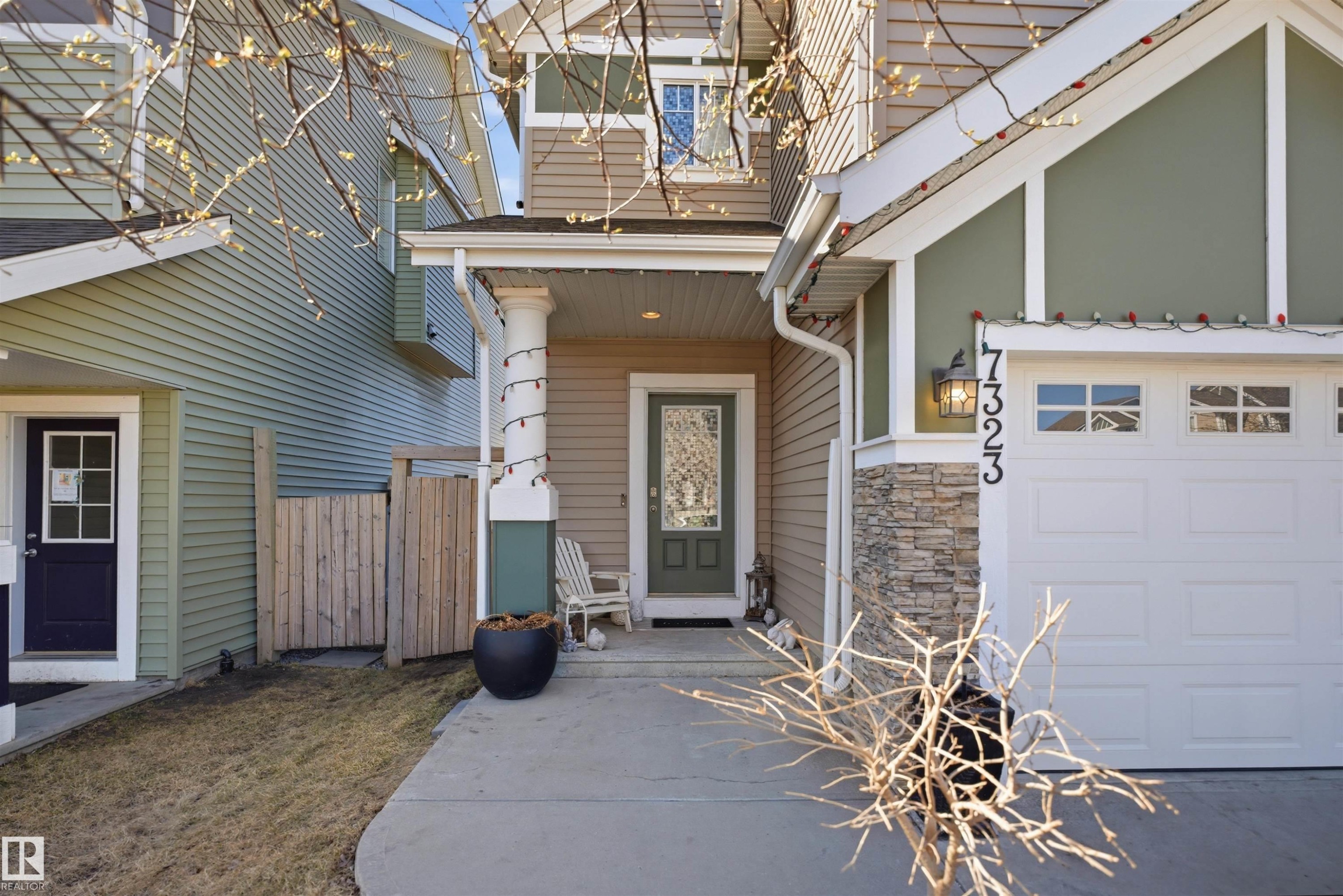 Front exterior featuring a covered porch entry, a two-story design, and an attached garage with panel windows - 7323 24 Ave, Edmonton, AB - Indoor Photo Showing Other Room