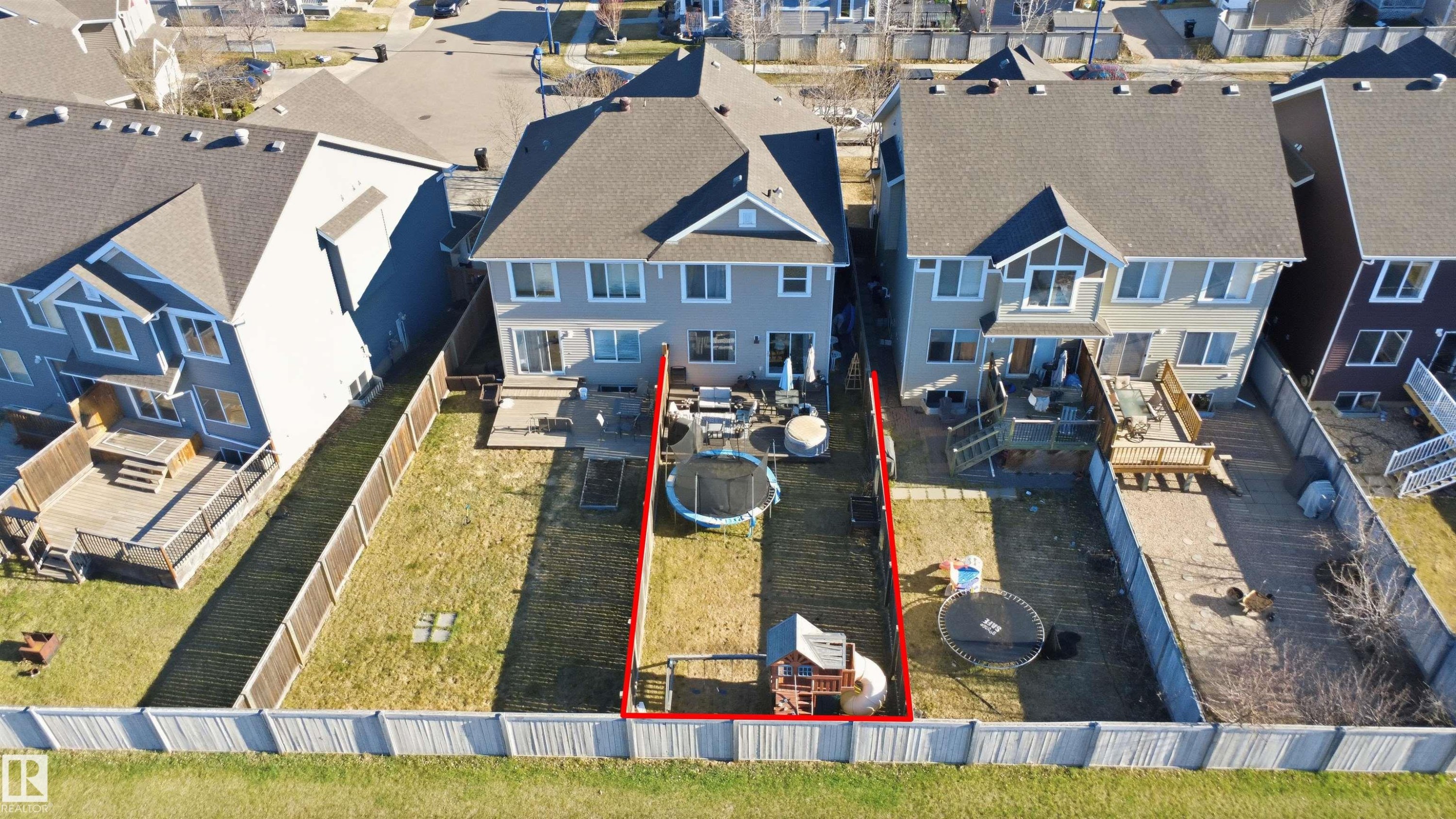 Rear exterior featuring a grey siding finish, dark shingle roof, and multiple windows across two levels - 7323 24 Ave, Edmonton, AB - Outdoor With Facade