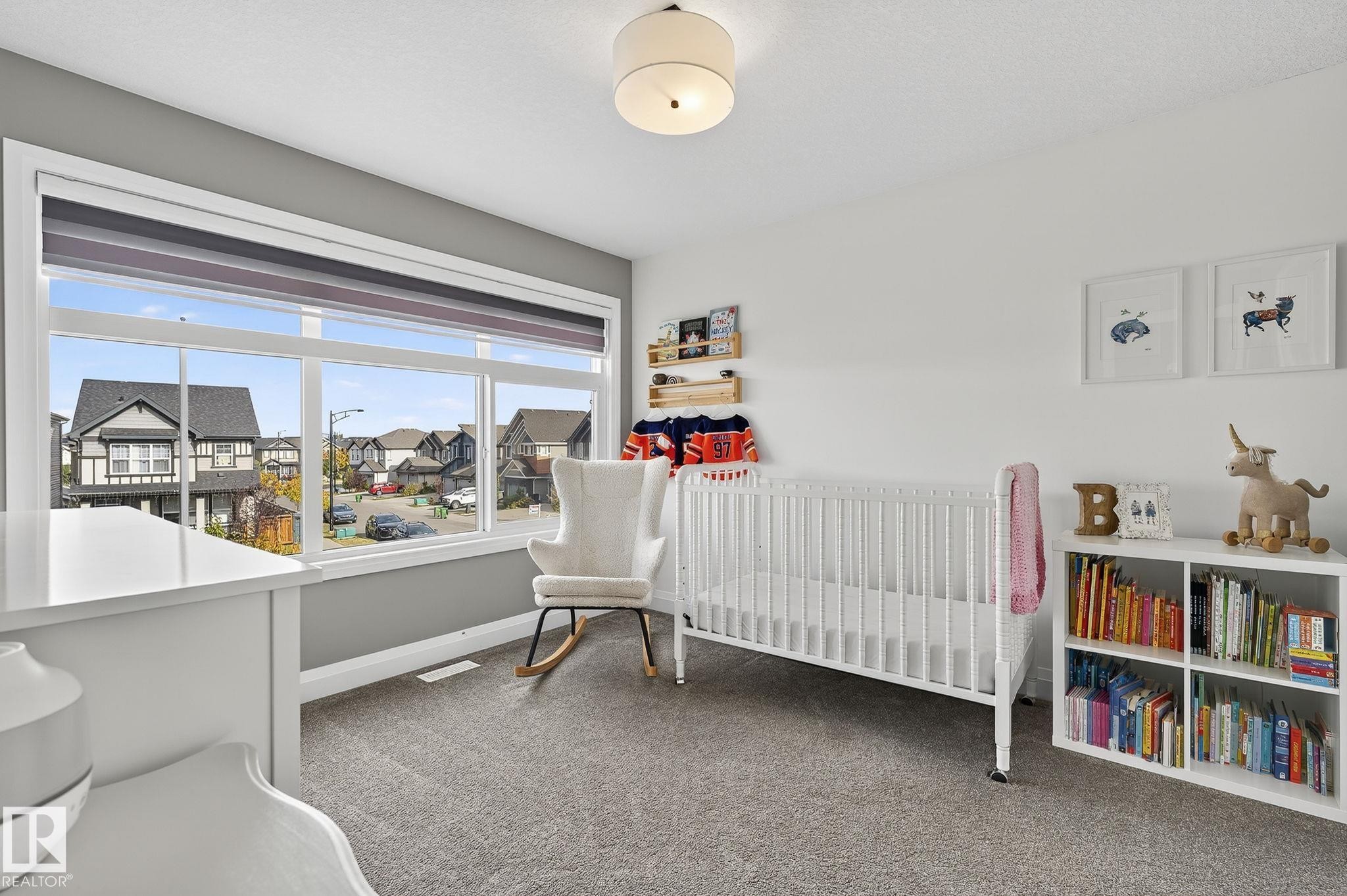 Room featuring a wide window with roller blinds, soft grey carpeting, and a flush mount ceiling light fixture - 1737 Dumont Crescent, Edmonton, AB - Indoor Photo Showing Bedroom
