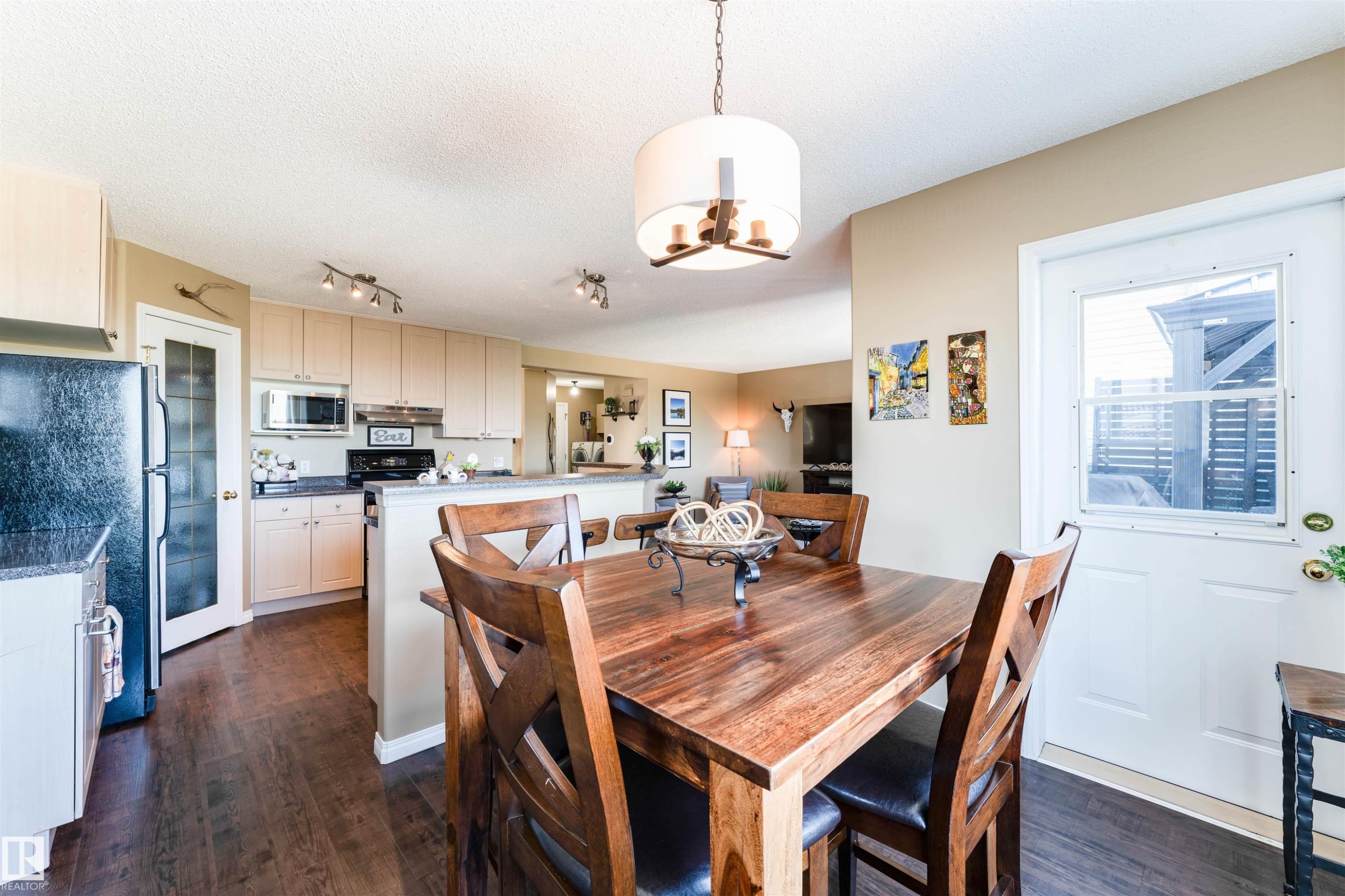 Dining area with wood-finish flooring and a central chandelier - 847 Blacklock Way, Edmonton, AB - Indoor Photo Showing Dining Room