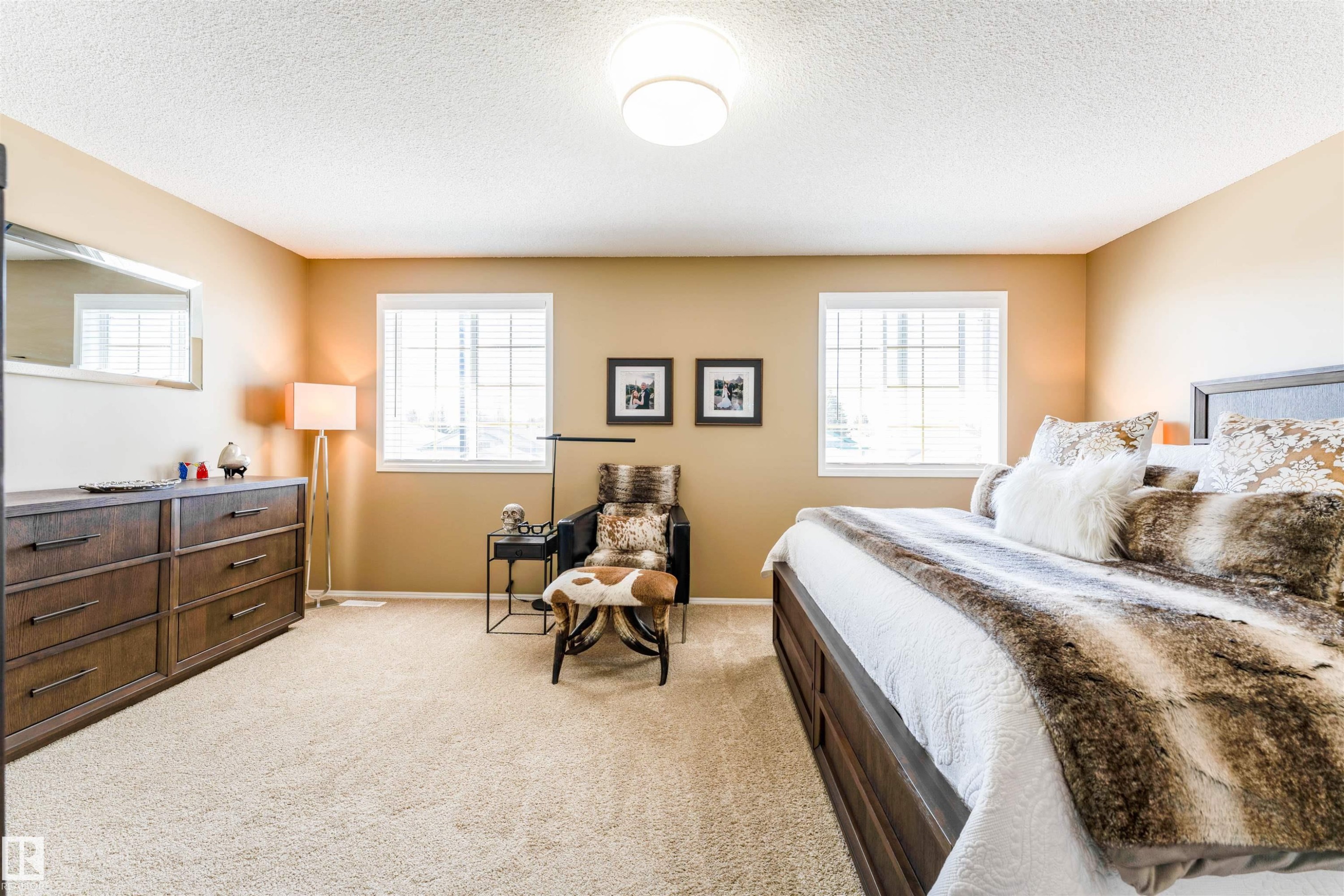 Spacious carpeted room featuring two window units with blinds, recessed lighting, and a neutral wall color - 847 Blacklock Way, Edmonton, AB - Indoor Photo Showing Bedroom