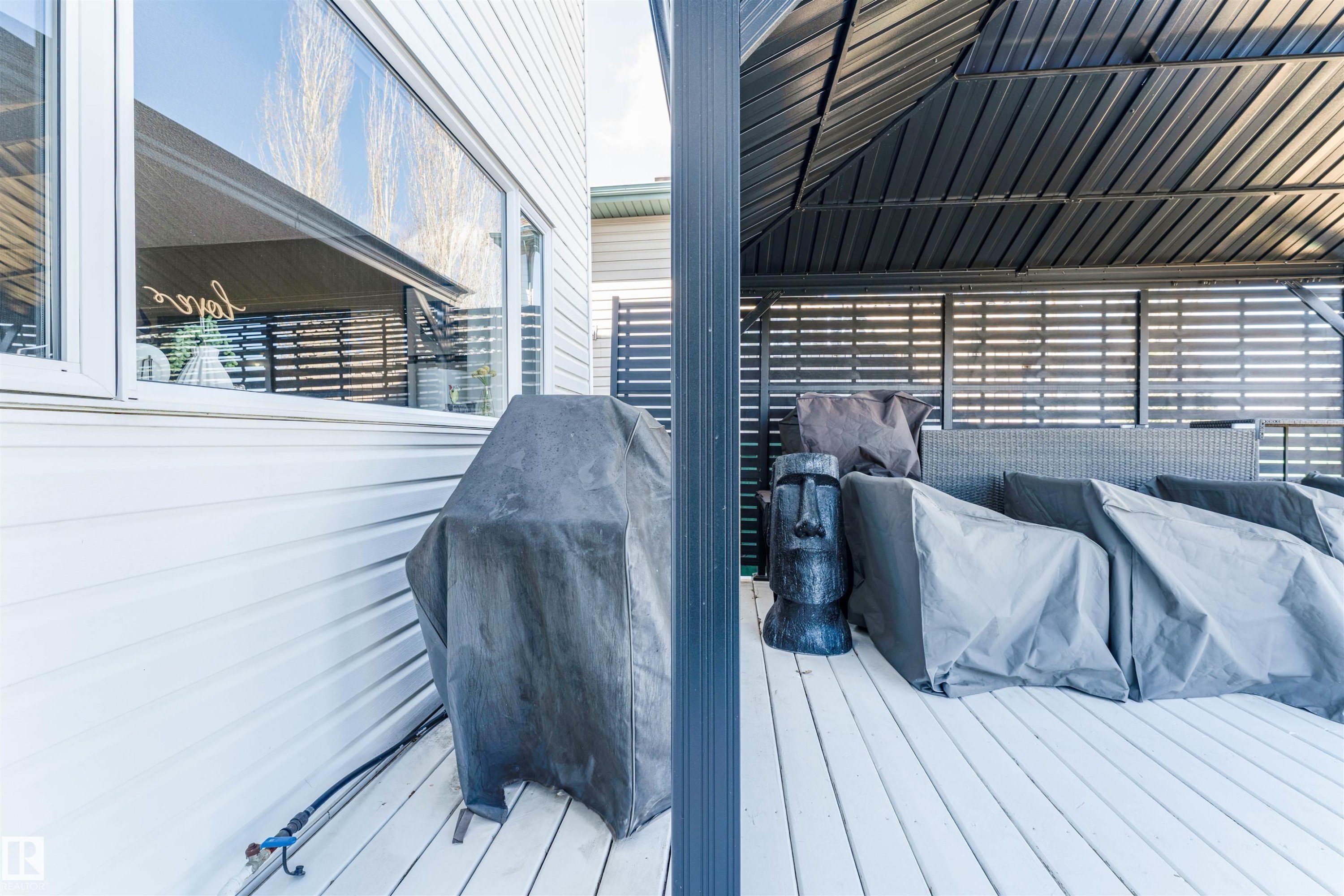 Exterior deck featuring a louvered pergola, privacy screens, and white horizontal siding - 847 Blacklock Way, Edmonton, AB - Outdoor With Deck Patio Veranda With Exterior
