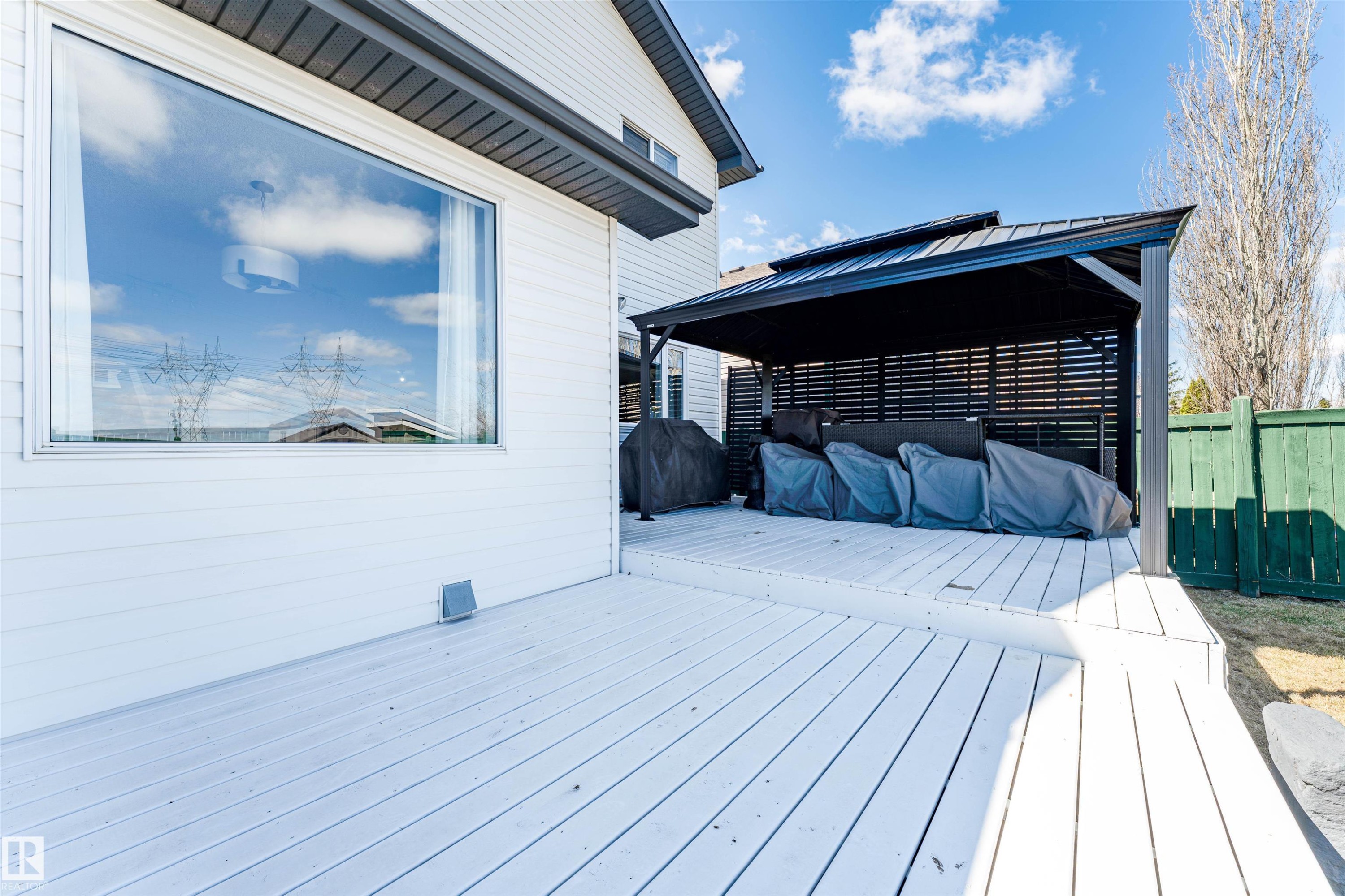 Expansive multi-level wood deck featuring a covered gazebo with slatted privacy screens, a wide picture window, and horizontal siding - 847 Blacklock Way, Edmonton, AB - Outdoor With Deck Patio Veranda With Exterior