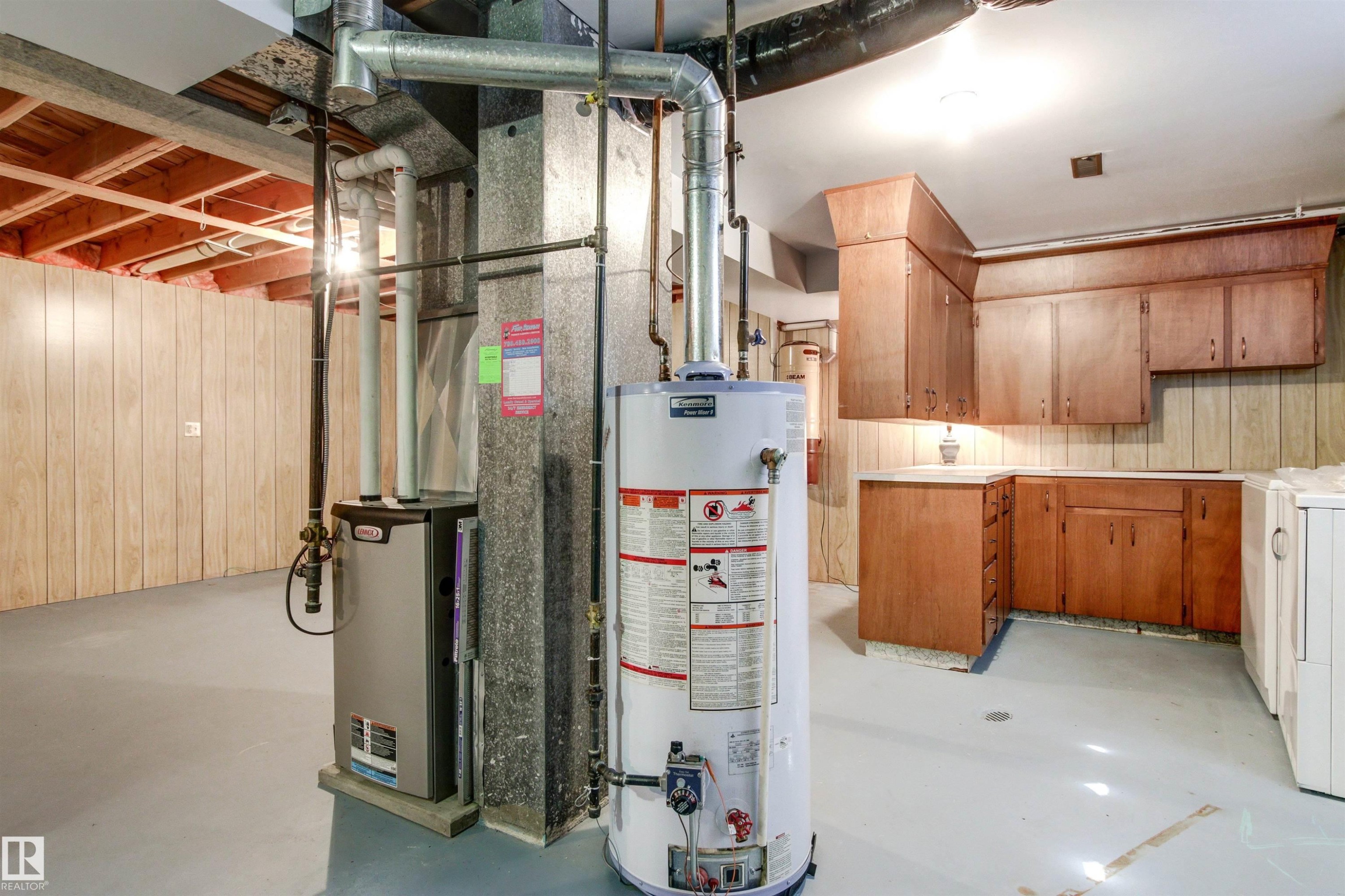Utility area featuring a water heater, furnace, wood-finish cabinetry, and laminate countertops - 29 Bristow Crescent, Spruce Grove, AB - Indoor Photo Showing Basement