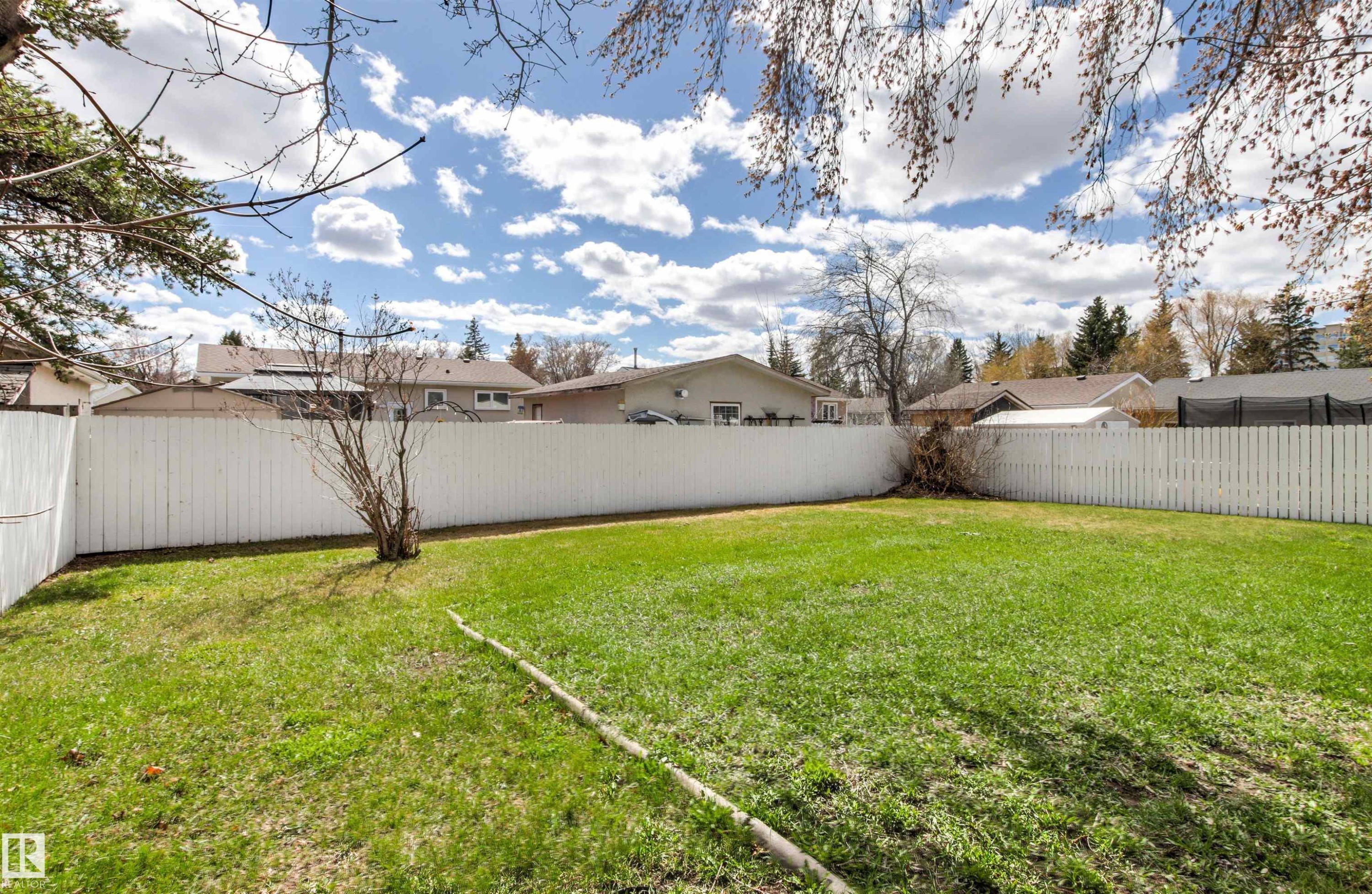 Expansive lawn area featuring a full-height white privacy fence - 29 Bristow Crescent, Spruce Grove, AB - Outdoor