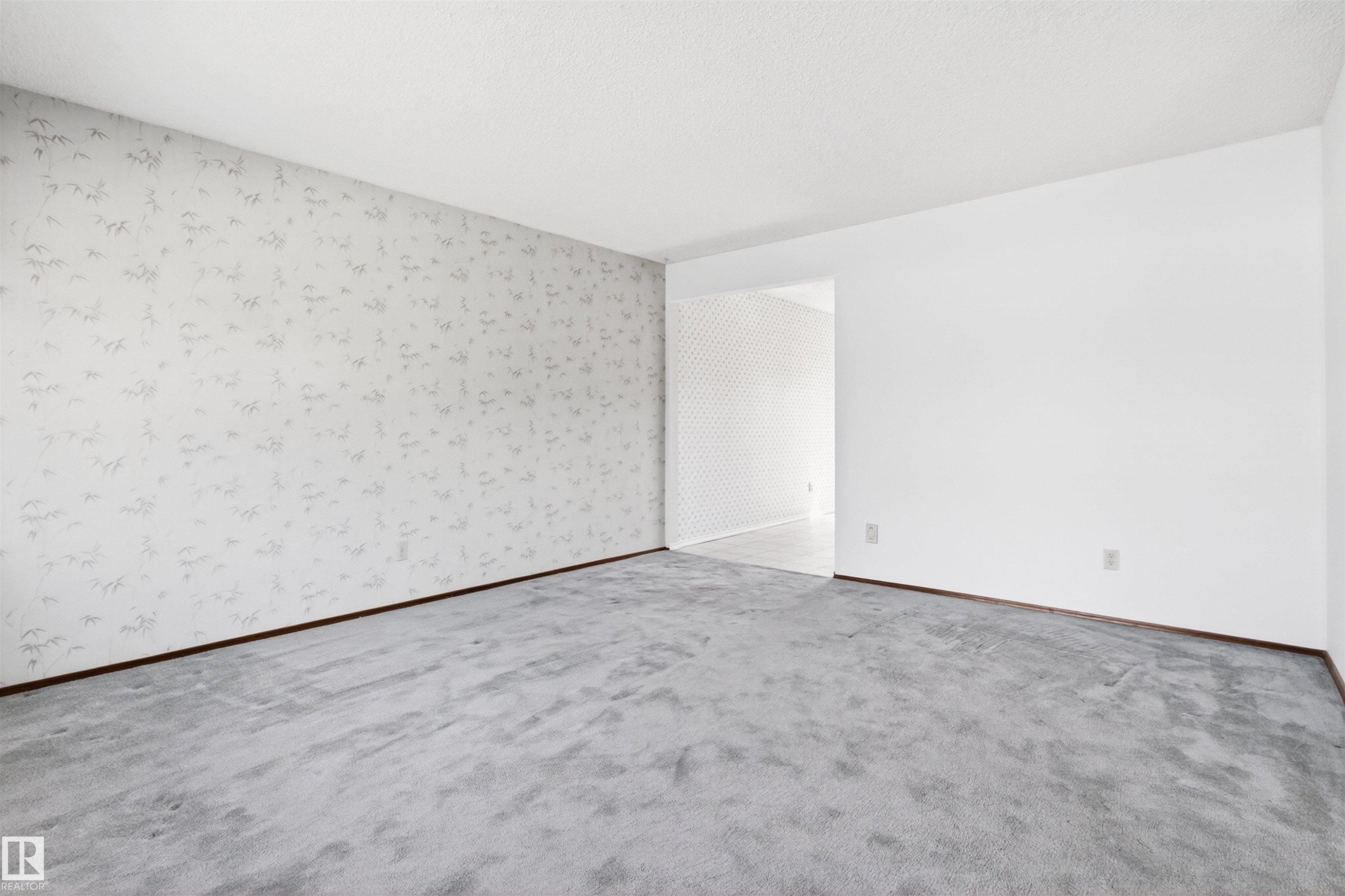 Spacious room with light gray patterned wallpaper, plush gray carpeting, and white painted walls - 29 Bristow Crescent, Spruce Grove, AB - Indoor Photo Showing Other Room