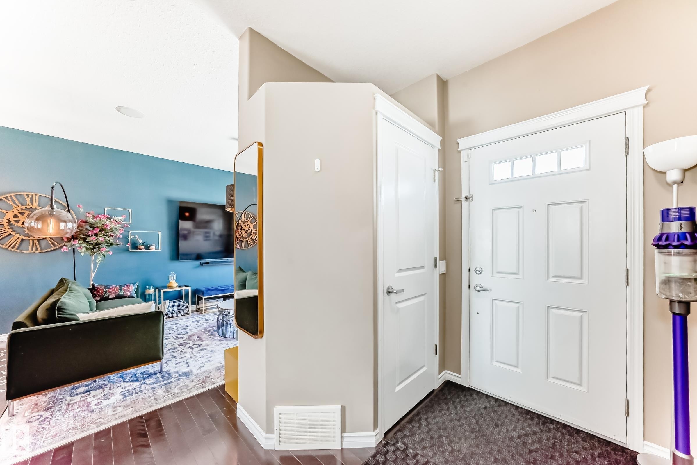 Entryway featuring a paneled front door with upper lites, wood-finish flooring, a built-in closet, and neutral wall tones - 5020 Orchards Gate, Edmonton, AB - Indoor Photo Showing Other Room