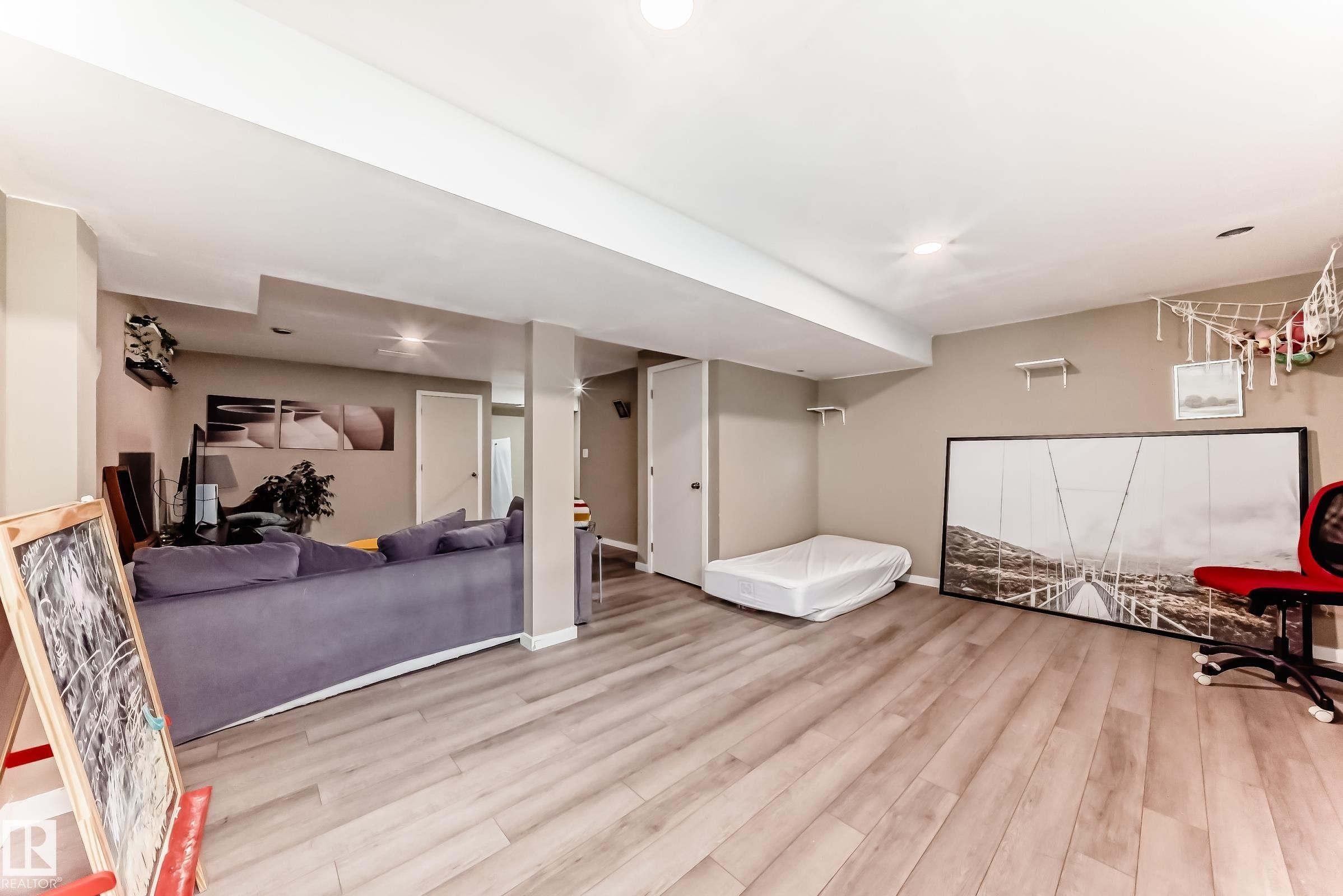 Spacious room featuring light wood-finish flooring, recessed lighting, and neutral wall tones - 5020 Orchards Gate, Edmonton, AB - Indoor Photo Showing Other Room