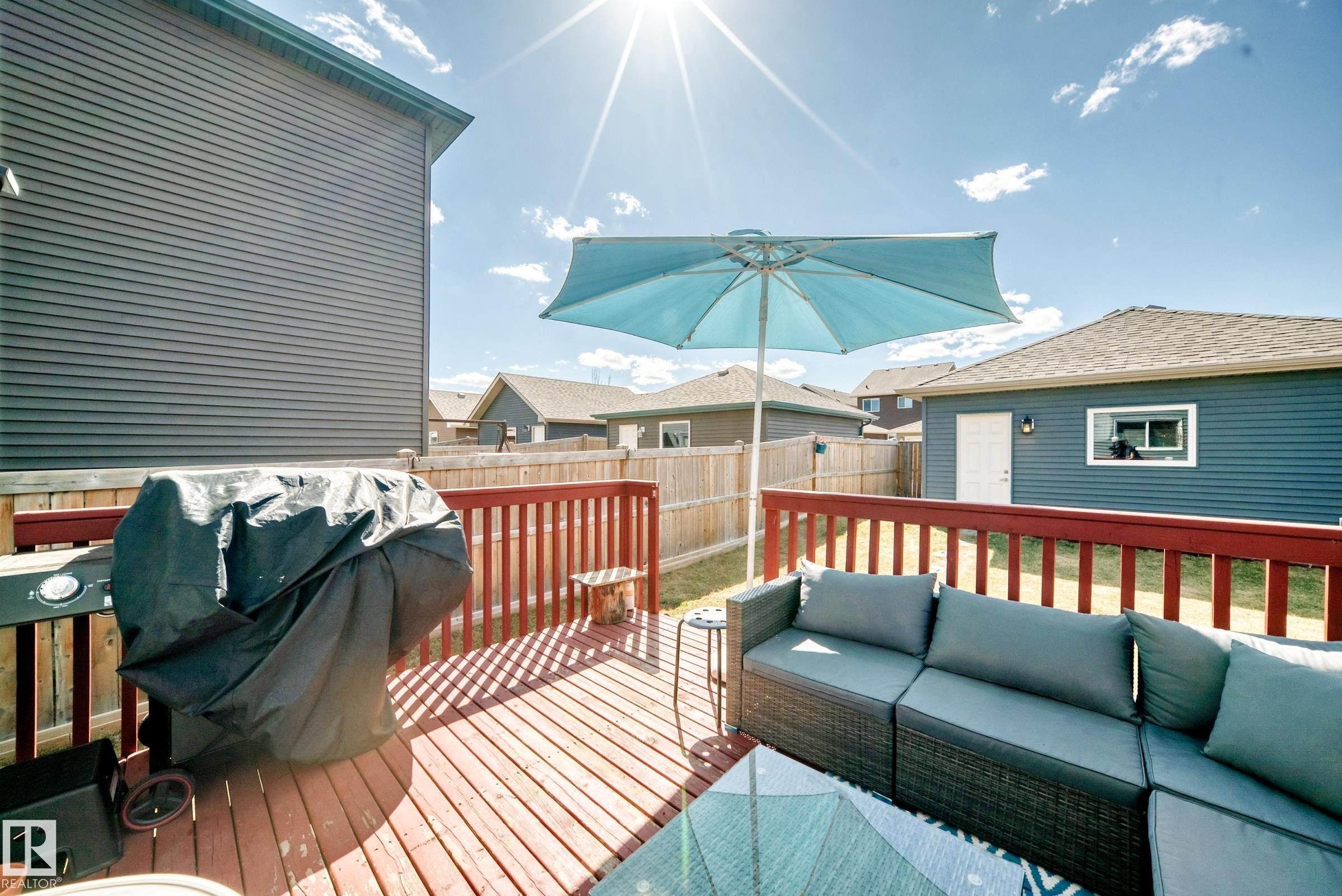 Expansive wooden deck featuring red railings and a surrounding privacy fence - 5020 Orchards Gate, Edmonton, AB - Outdoor With Deck Patio Veranda With Exterior