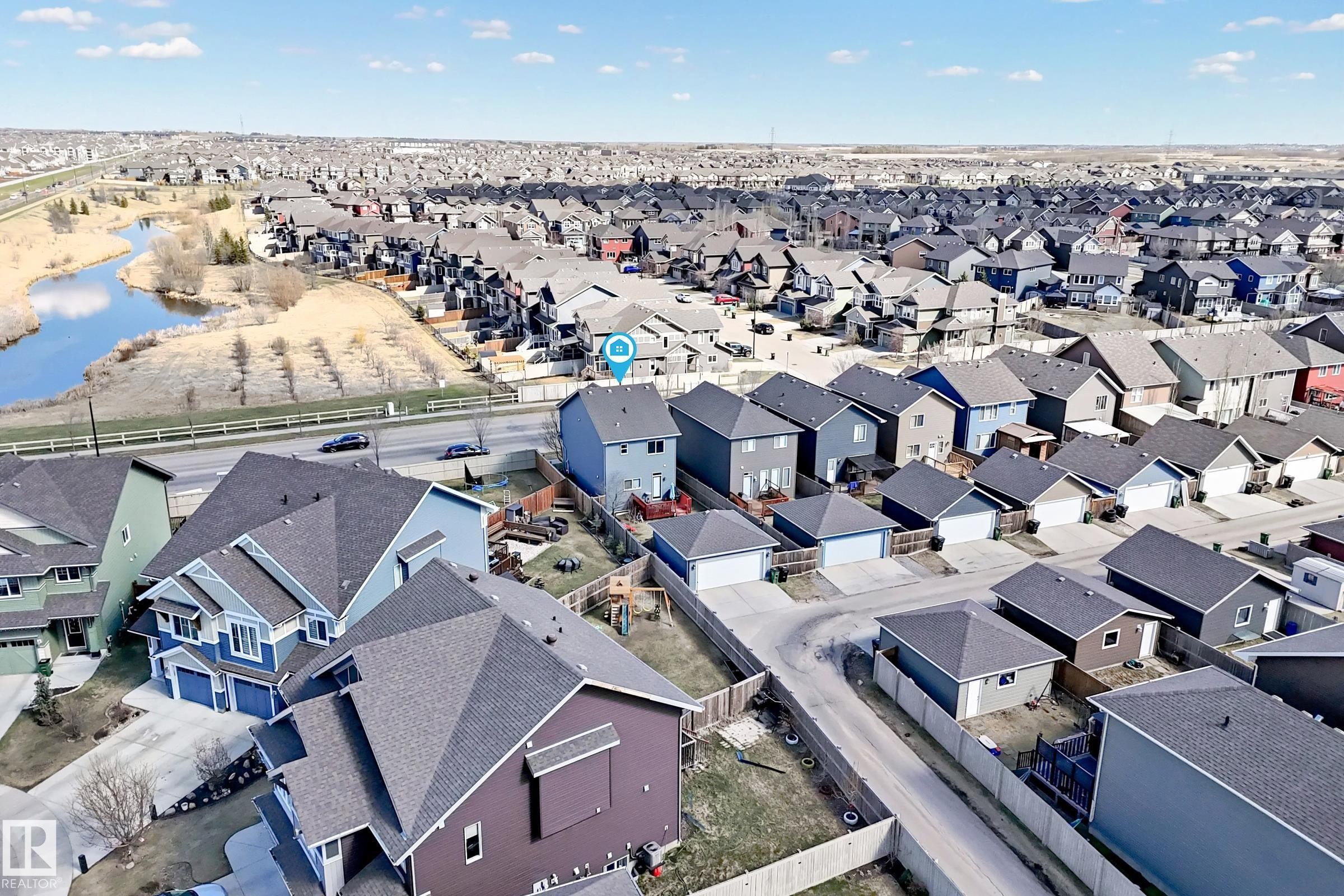 Residential neighborhood featuring a mix of single-family homes and a natural water feature - 5020 Orchards Gate, Edmonton, AB - Outdoor With View