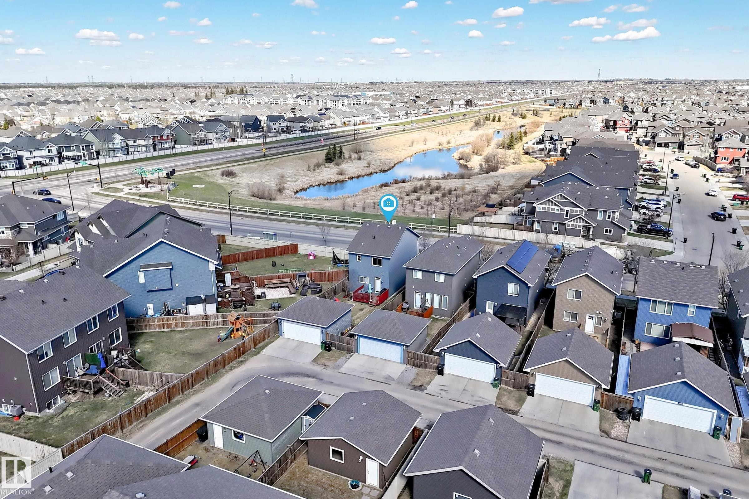 Aerial perspective showcasing a residential neighborhood with detached homes, each featuring individual garages and fenced backyards - 5020 Orchards Gate, Edmonton, AB - Outdoor With View