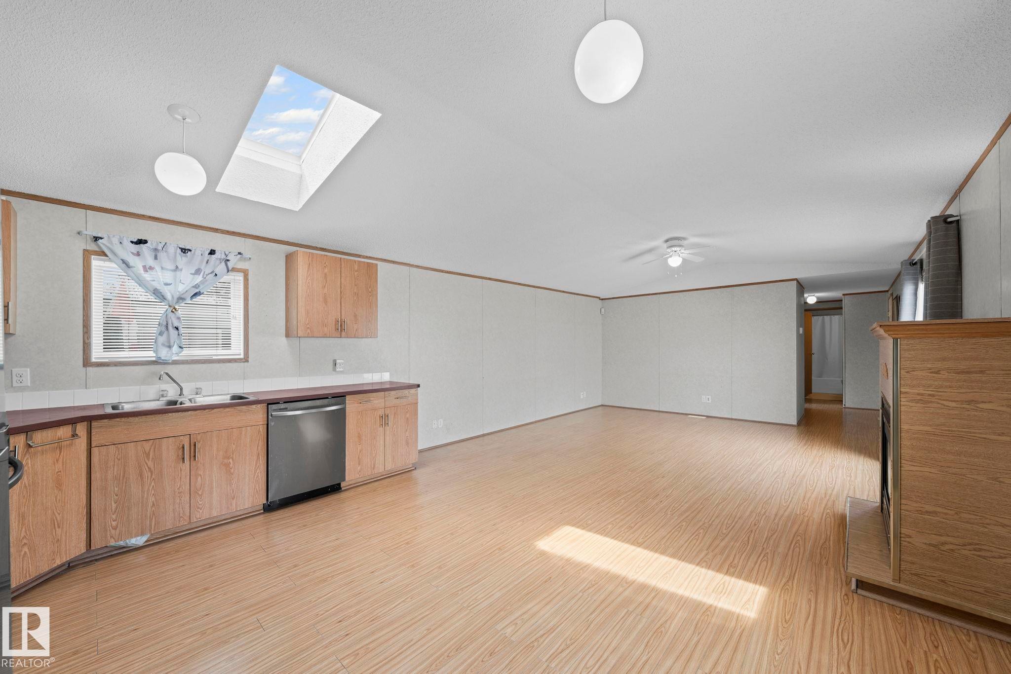 Open-concept living area with wood-finish flooring - 623 Evergreen Park, Edmonton, AB - Indoor Photo Showing Kitchen With Double Sink