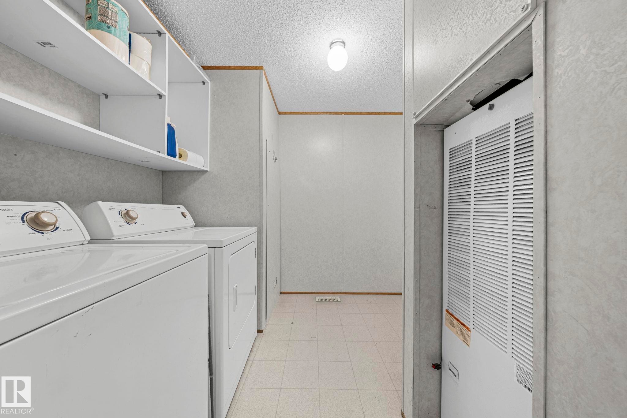 Dedicated utility area featuring built-in shelving, tiled flooring, and an integrated appliance space - 623 Evergreen Park, Edmonton, AB - Indoor Photo Showing Laundry Room