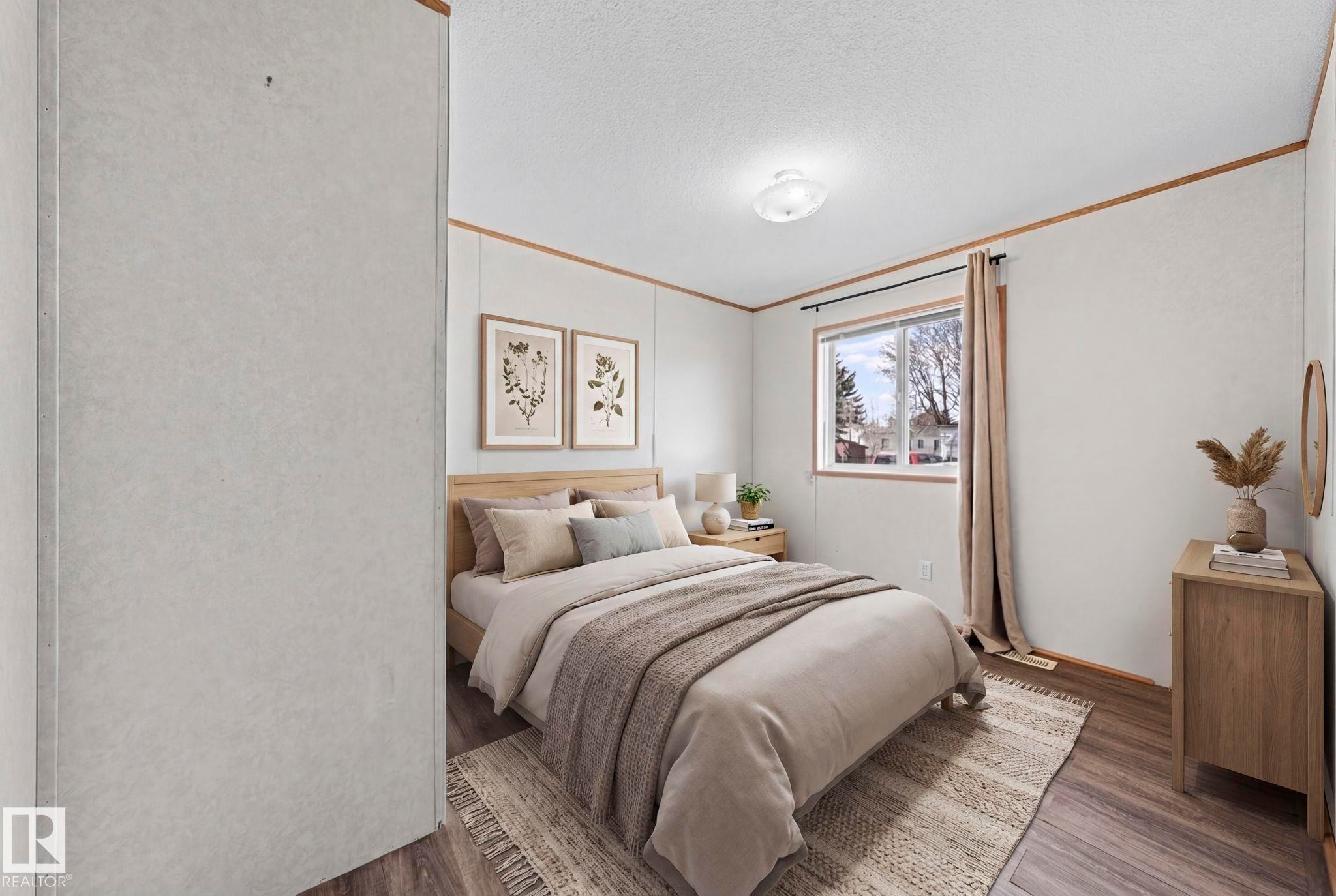 Room featuring wood-finish flooring, a window with natural light, a ceiling-mounted light fixture, and horizontal wall paneling with wood trim accents - 623 Evergreen Park, Edmonton, AB - Indoor Photo Showing Bedroom