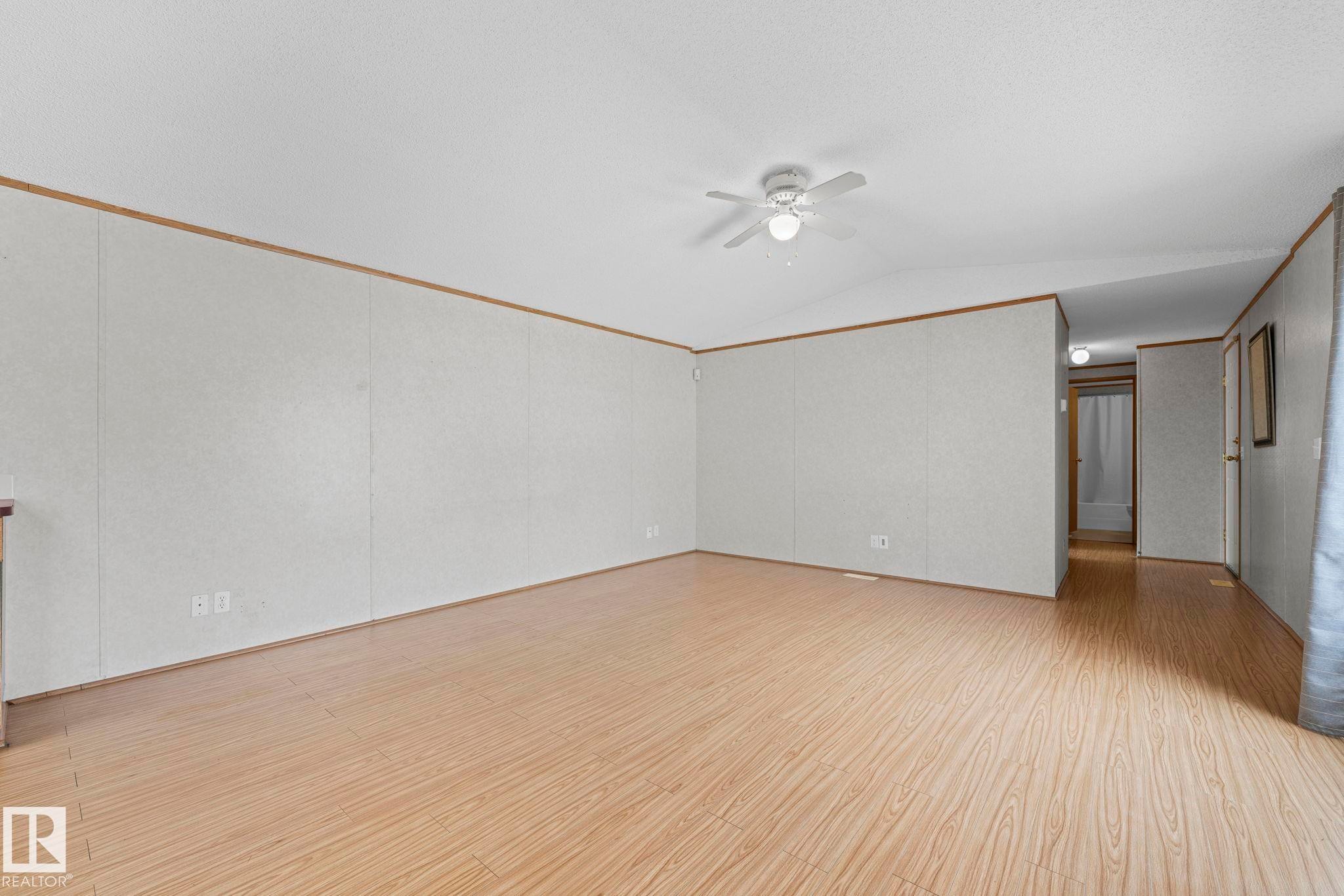 Spacious room featuring light wood-finish flooring and a white ceiling fan - 623 Evergreen Park, Edmonton, AB - Indoor Photo Showing Other Room