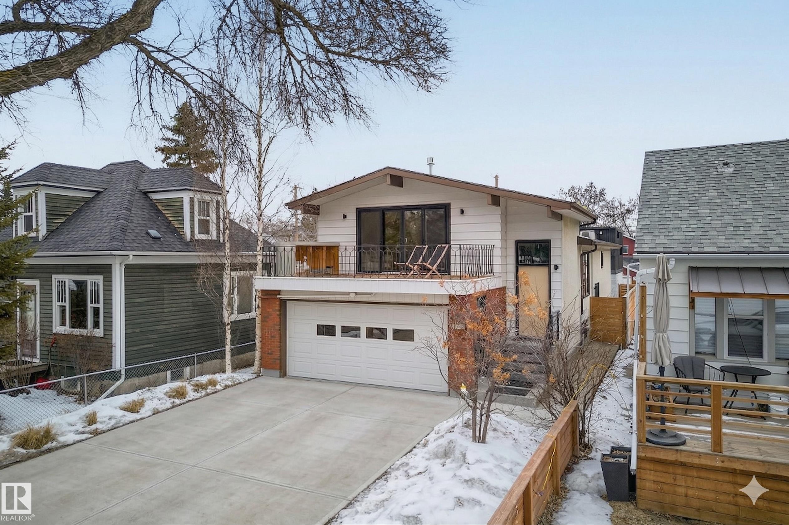The property features a spacious driveway leading to an integrated garage - 9736 78 Avenue, Edmonton, AB - Outdoor