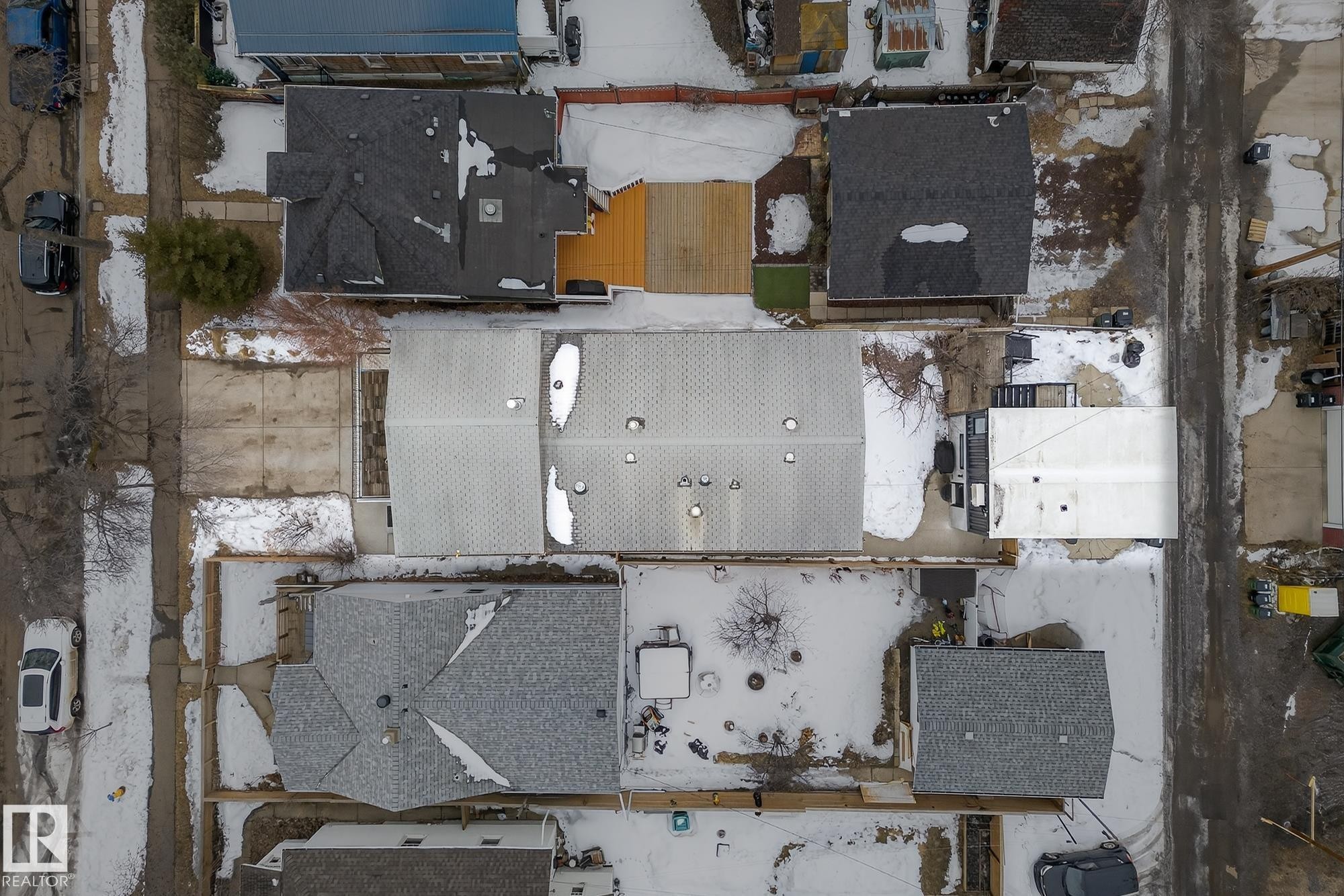 Aerial view showcasing the property's roof with visible vents, and surrounding properties with varying roof styles and yard areas - 9736 78 Avenue, Edmonton, AB -
