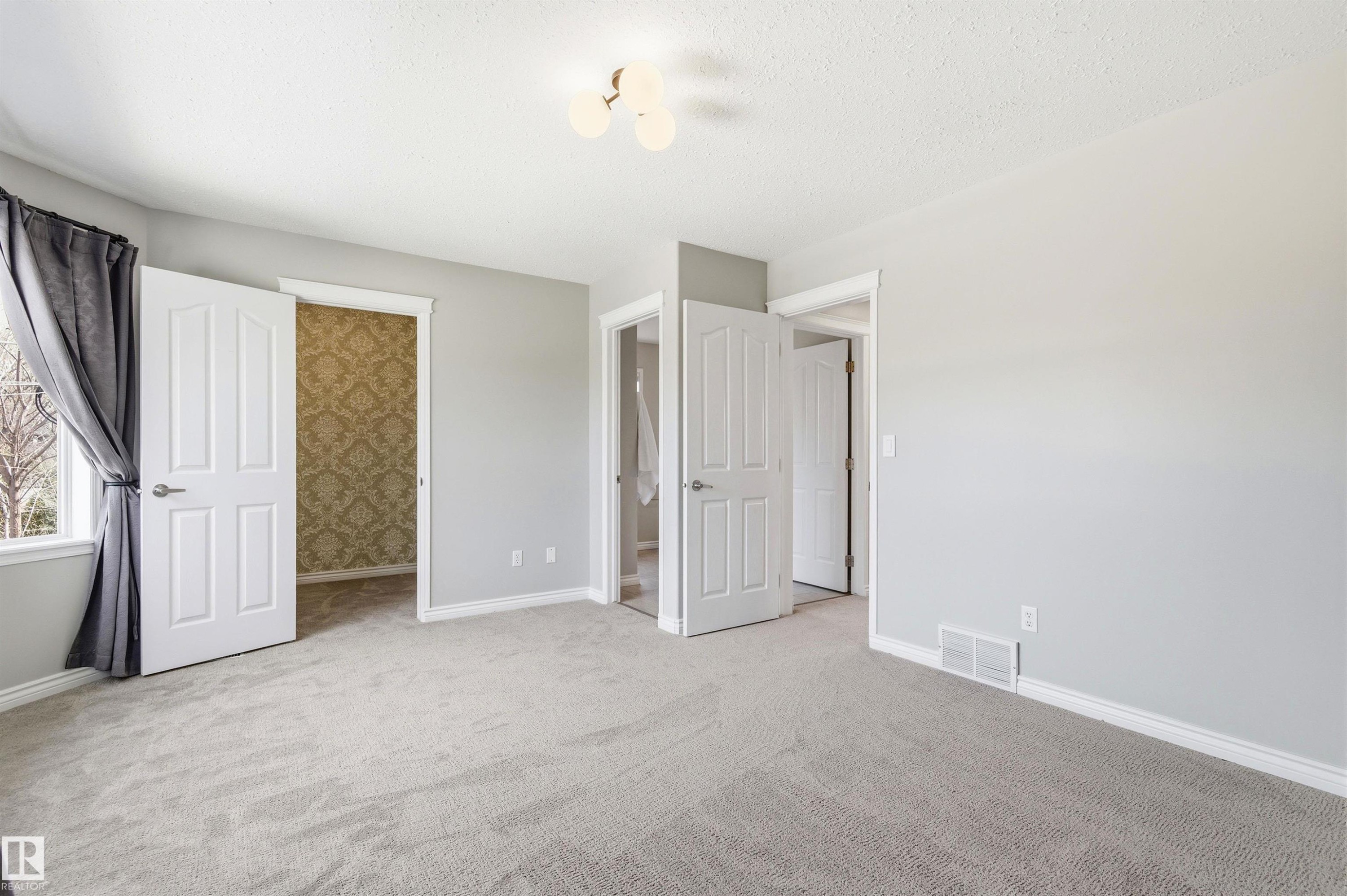 Light gray interior with soft carpeting, featuring white trim and baseboards - 8730 92A Avenue, Edmonton, AB - Indoor