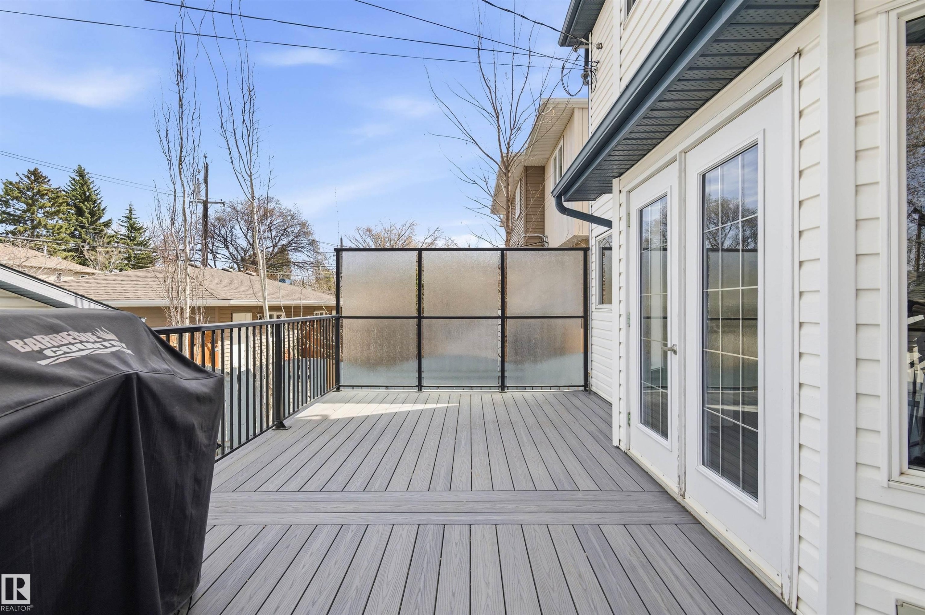 Spacious outdoor deck featuring composite decking and black metal railings - 8730 92A Avenue, Edmonton, AB - Outdoor With Deck Patio Veranda With Exterior