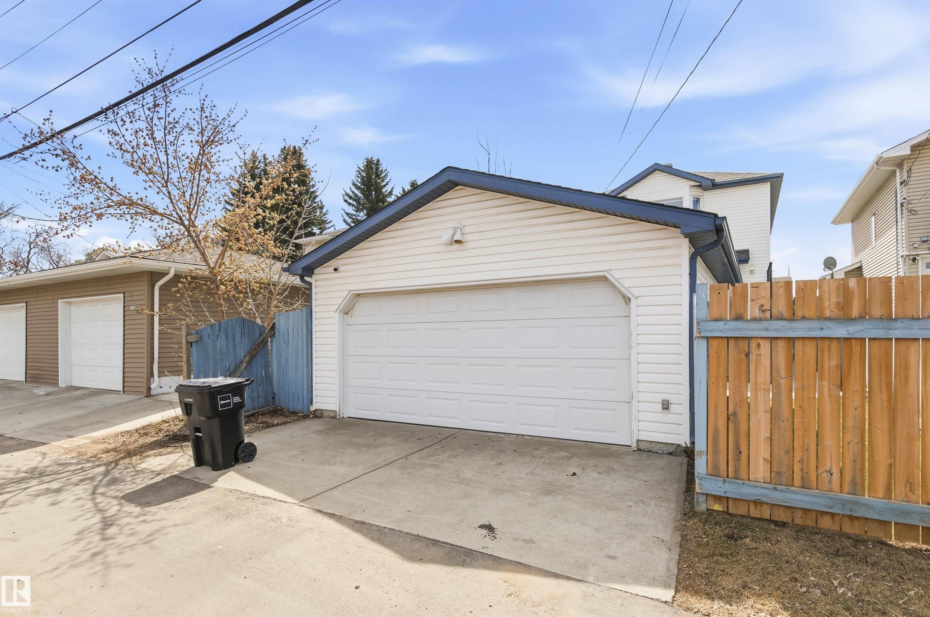 Detached garage with horizontal siding, a blue-trimmed roofline, and a concrete driveway - 8730 92A Avenue, Edmonton, AB - Outdoor With Exterior