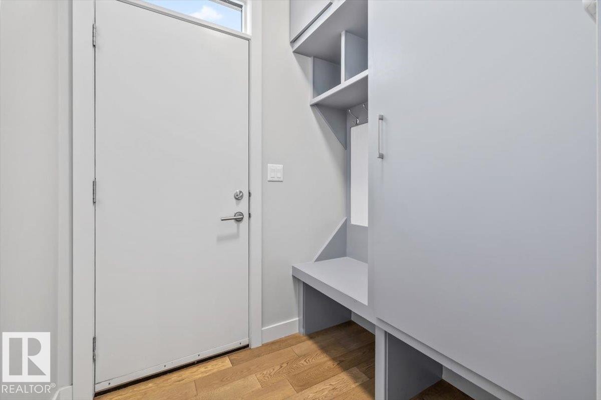 Entryway mudroom featuring a built-in storage system, coat hooks, and a bench - 8706 88 Avenue, Edmonton, AB - Indoor Photo Showing Other Room