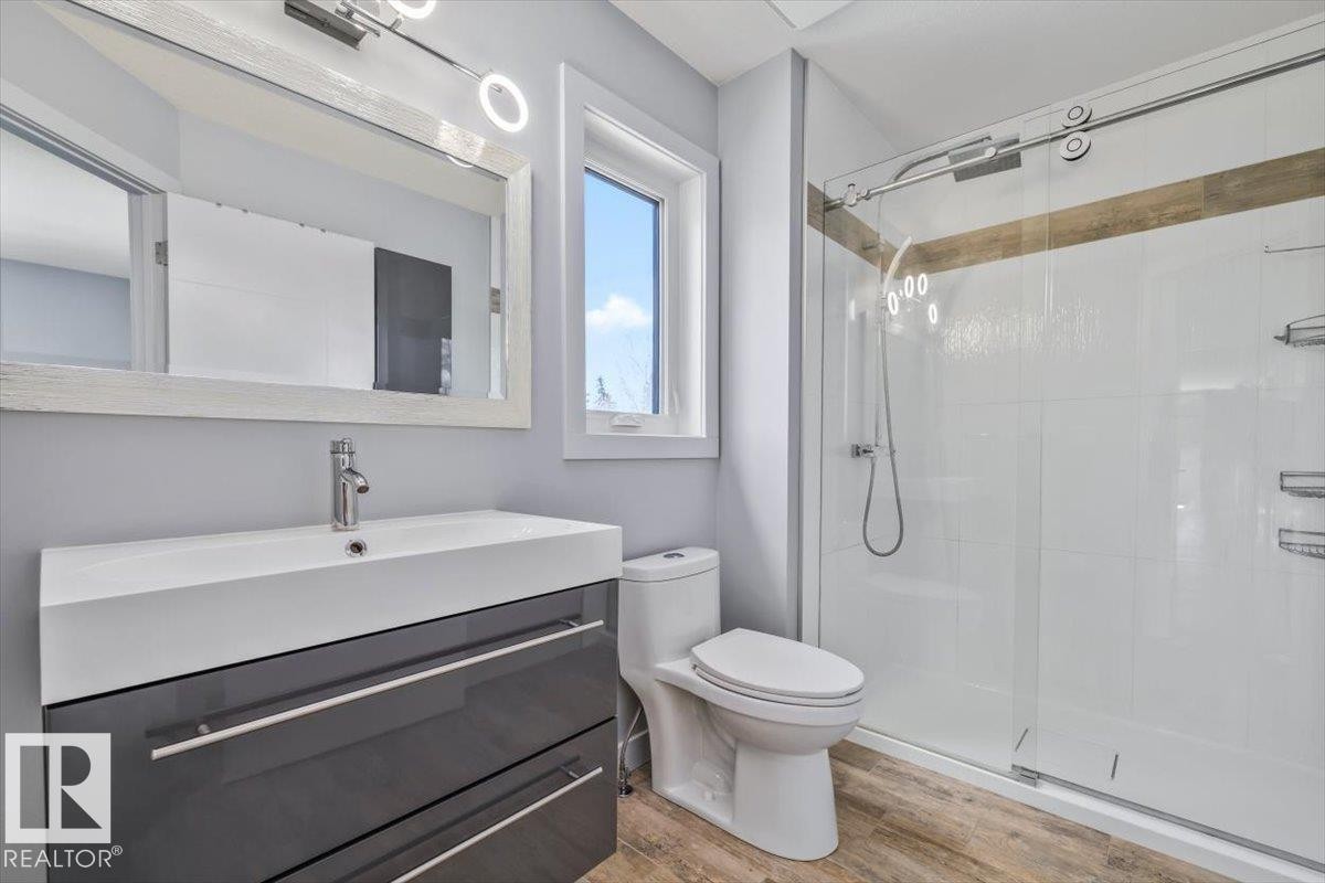 Bathroom featuring a floating vanity with integrated sink, chrome faucet, and glossy gray cabinetry - 8706 88 Avenue, Edmonton, AB - Indoor Photo Showing Bathroom
