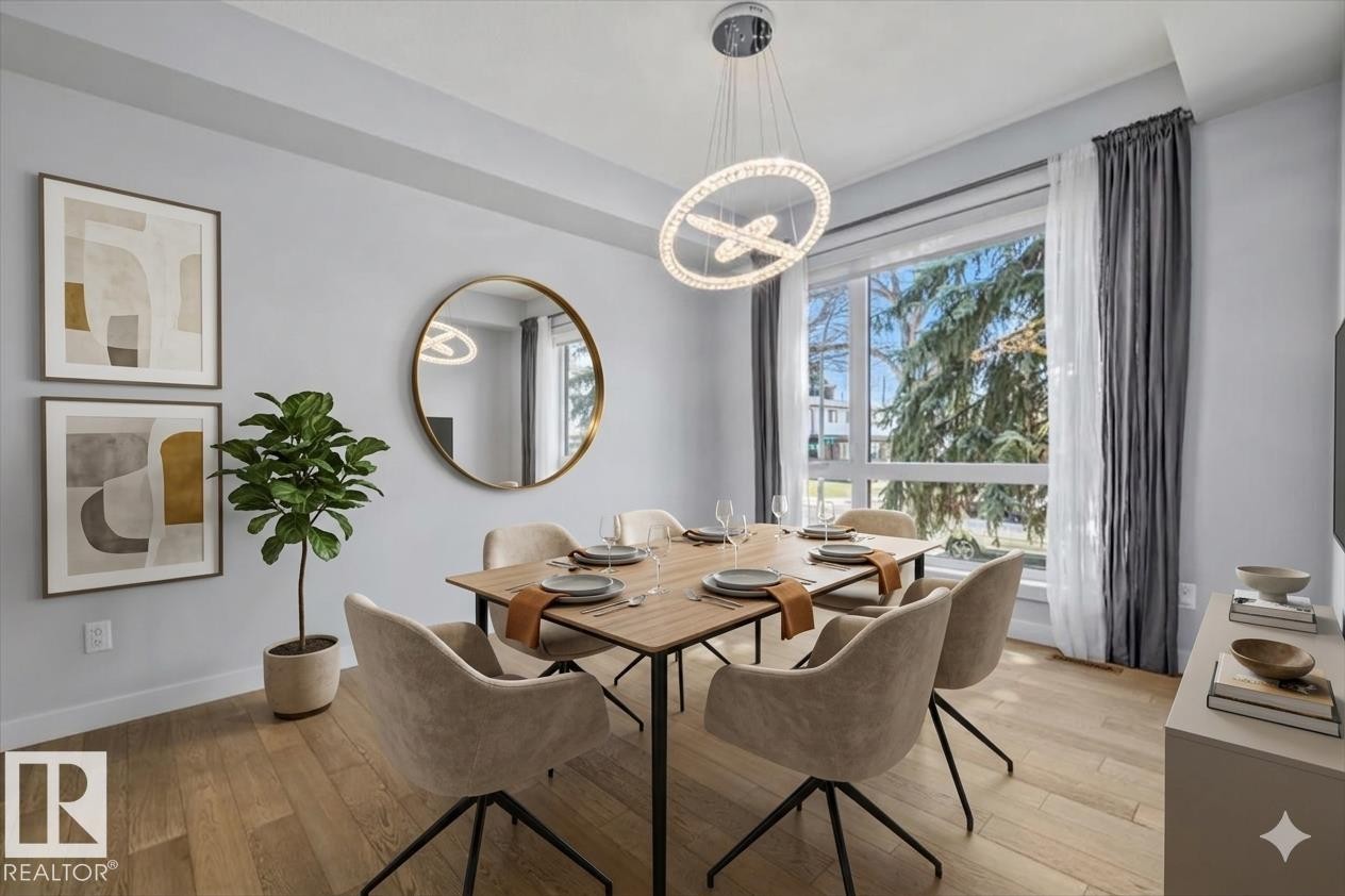 Bright dining area featuring a contemporary chandelier, wood-finish flooring, and a large window - 8706 88 Avenue, Edmonton, AB - Indoor Photo Showing Dining Room