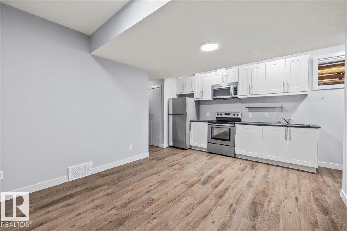 Open-concept living space with wood-finish flooring - 8706 88 Avenue, Edmonton, AB - Indoor Photo Showing Kitchen