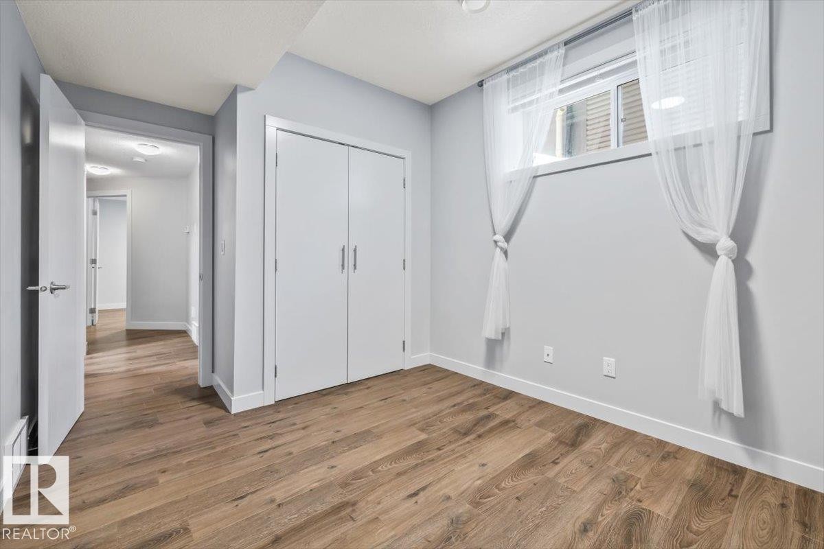 Room featuring wood-finish flooring, light gray wall paint, and white trim - 8706 88 Avenue, Edmonton, AB - Indoor Photo Showing Other Room