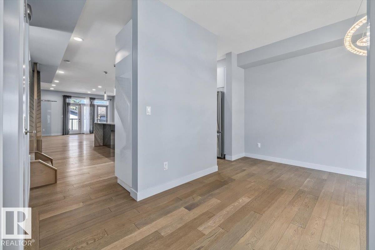 Expansive open-concept living space featuring wood-finish flooring throughout - 8706 88 Avenue, Edmonton, AB - Indoor Photo Showing Other Room