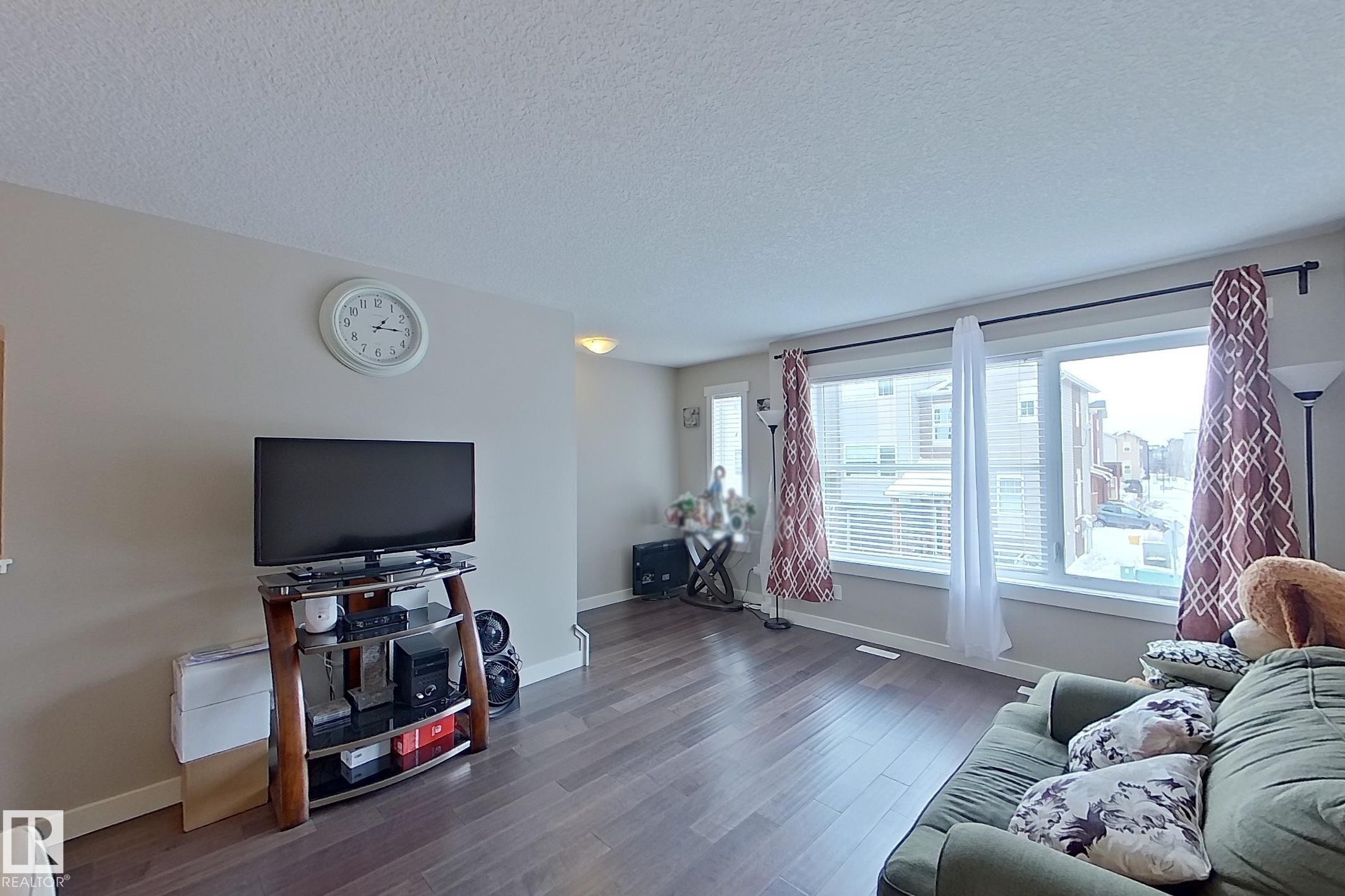 Living area featuring dark wood-finish flooring and neutral wall tones - 295 401 Southfork, Leduc, AB - Indoor Photo Showing Living Room