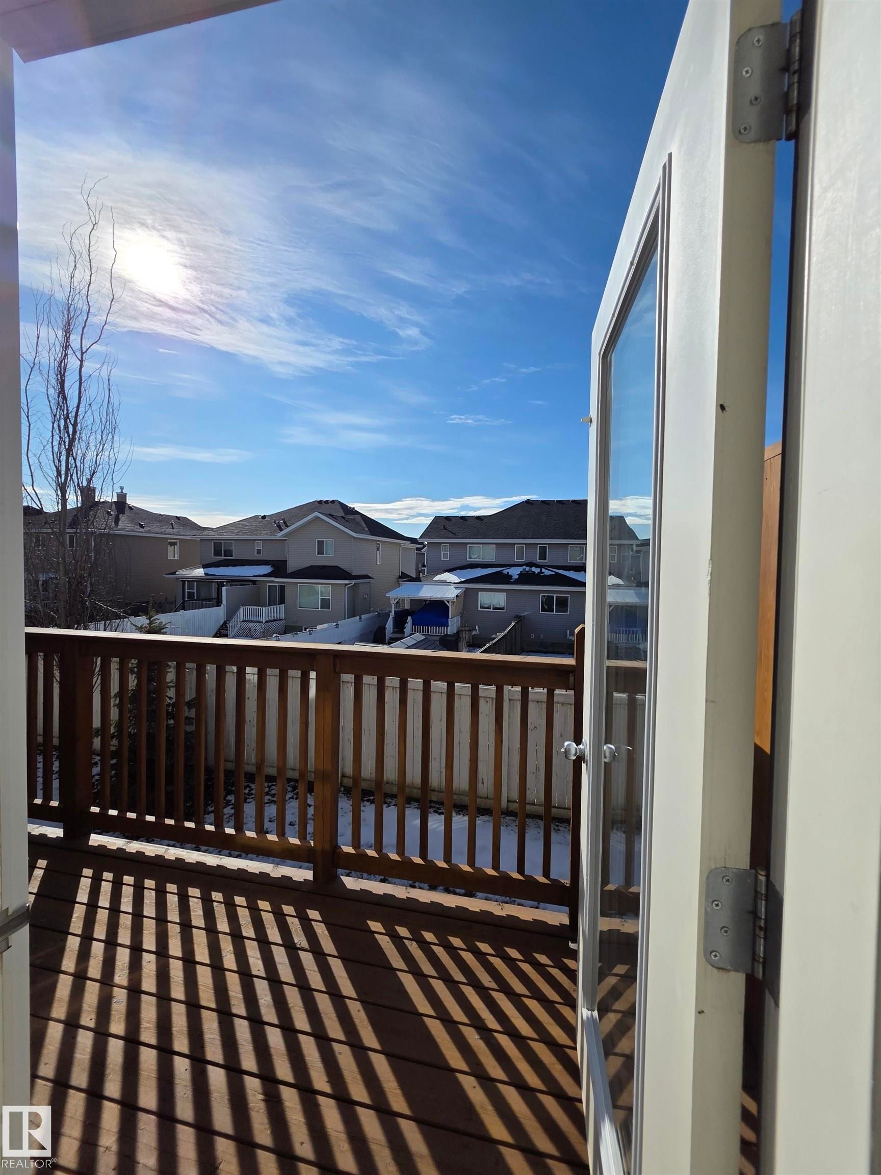 Outdoor wood-finish deck with vertical railing and a privacy fence - 295 401 Southfork, Leduc, AB - Outdoor
