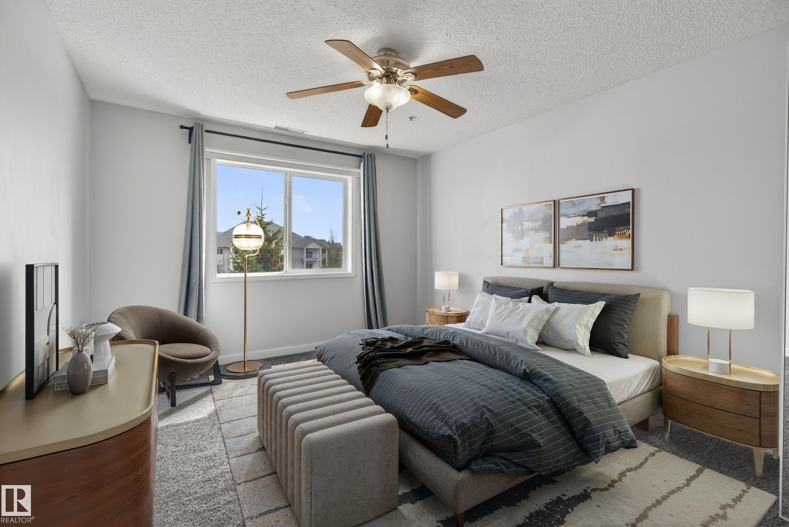 Spacious bedroom featuring light gray walls, a window with a view of residential structures, a ceiling fan with integrated lighting, and carpeted flooring - #319 16303 95 St Nw, Edmonton, AB - Indoor Photo Showing Bedroom