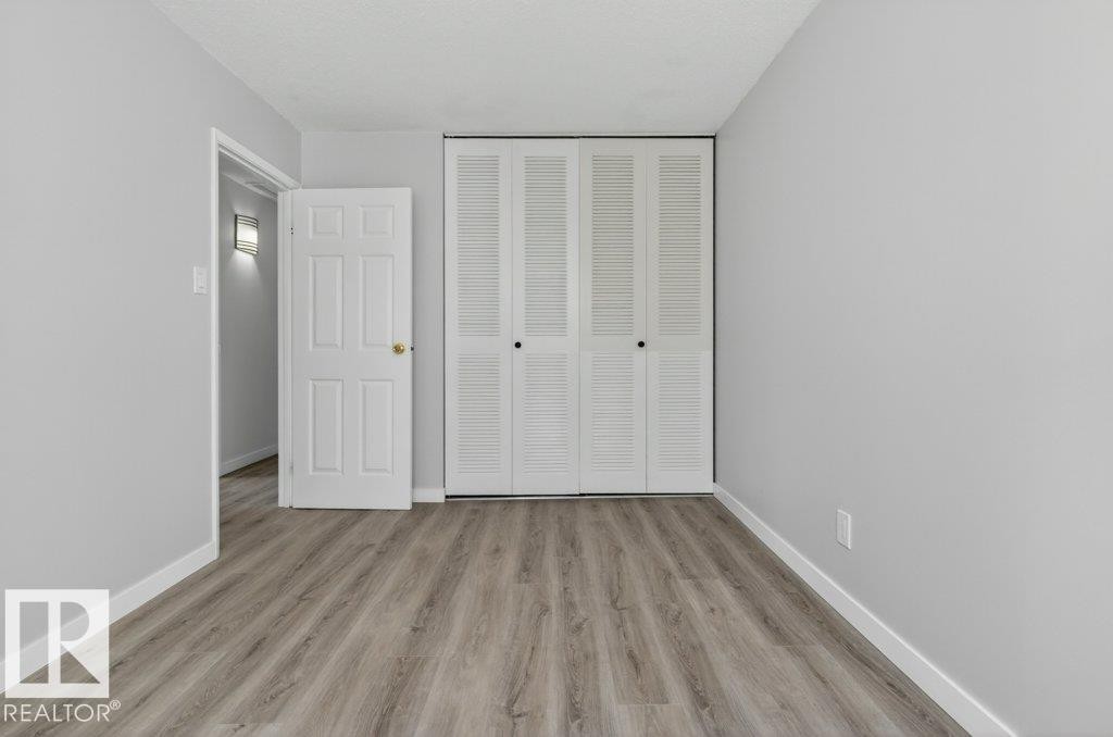 Light gray wall color complementing the wood-finish flooring - 3E Twin Terrace, Edmonton, AB - Indoor Photo Showing Other Room