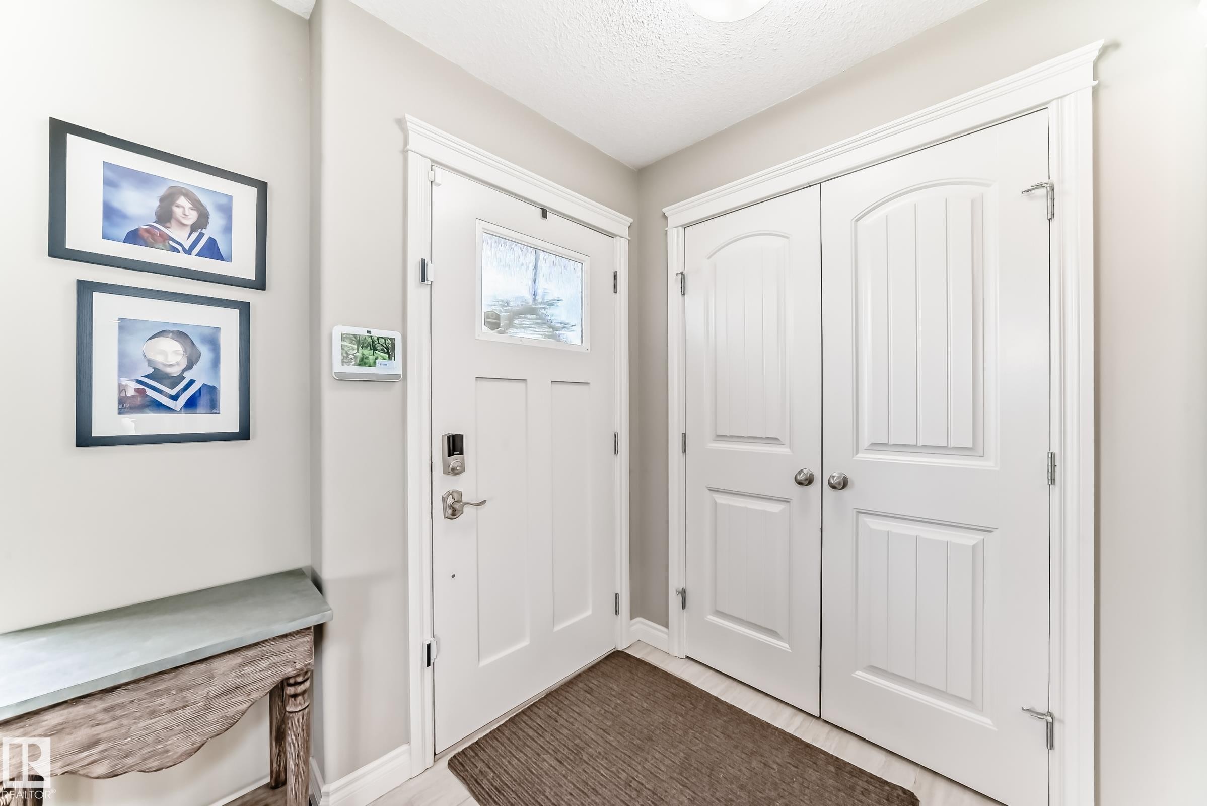 Entryway featuring a white paneled door with a clear glass insert, brushed nickel hardware, and a digital keyless entry system - 10519 114 Avenue, Edmonton, AB - Indoor Photo Showing Other Room
