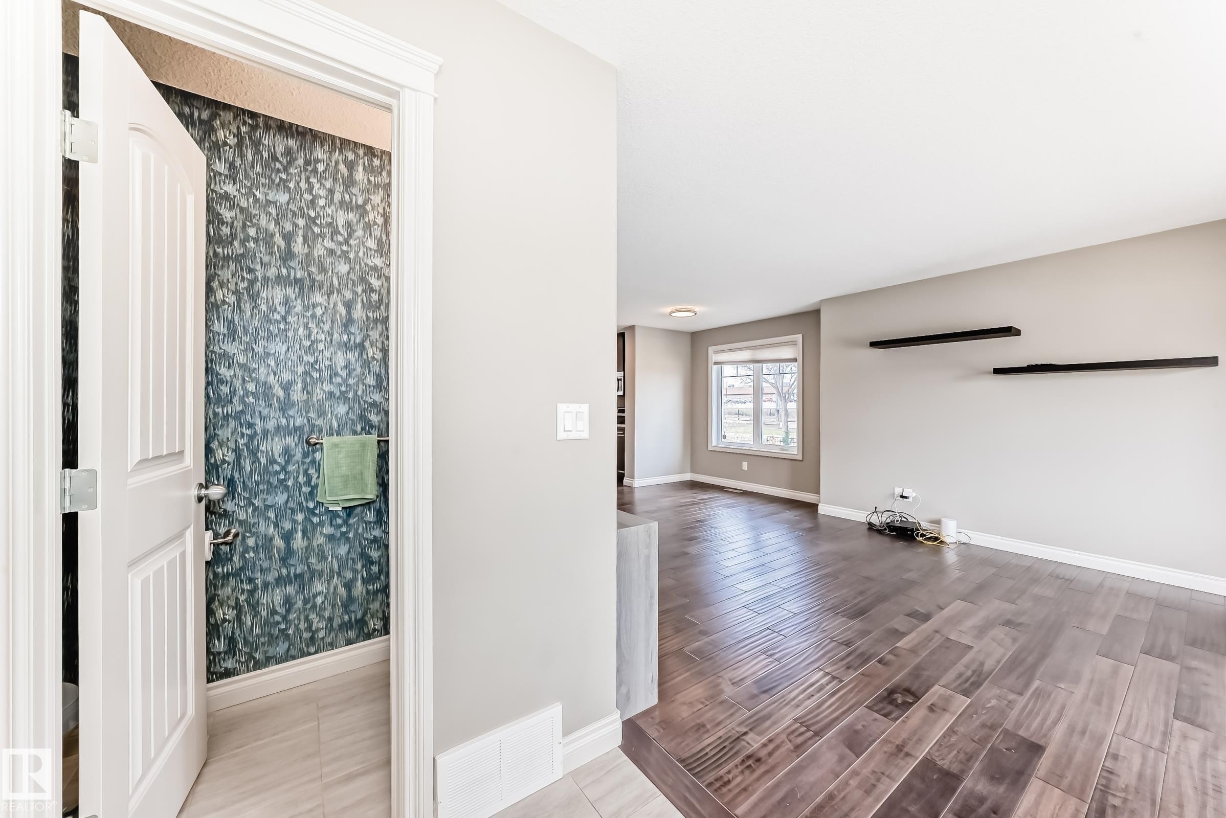 Spacious interior featuring wide plank wood-finish flooring and light gray painted walls - 10519 114 Avenue, Edmonton, AB - Indoor Photo Showing Other Room