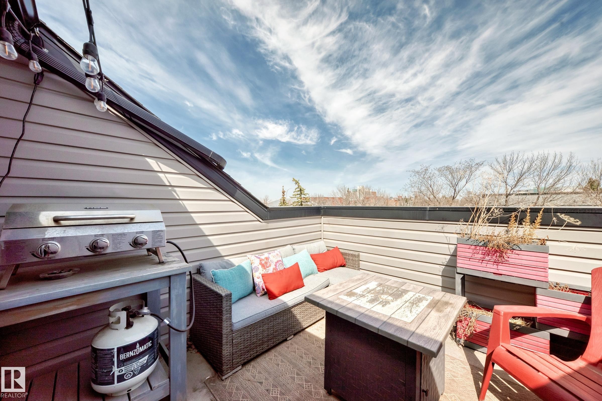 Rooftop patio featuring light gray siding, string lighting, and a dark railing - 10519 114 Avenue, Edmonton, AB - Outdoor With Exterior