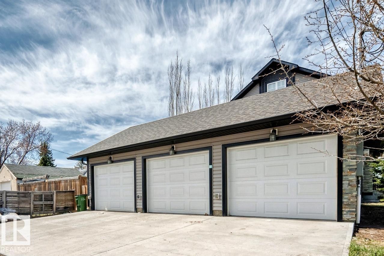 Three-car garage with white panel doors and exterior lighting fixtures - 10519 114 Avenue, Edmonton, AB - Outdoor With Exterior
