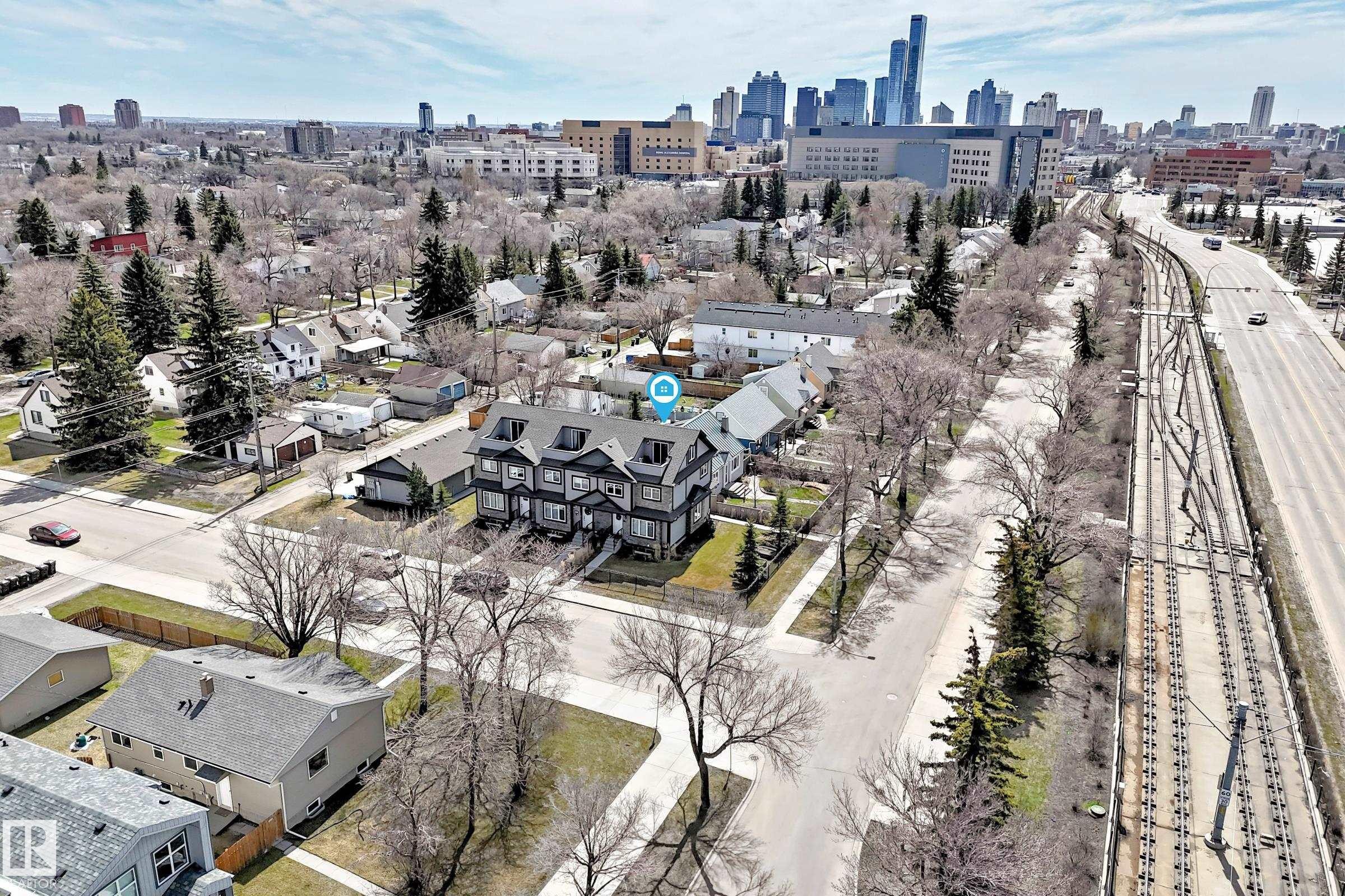 Multi-unit residential property featuring a dark exterior with light trim, multiple dormer windows, and a prominent front entrance - 10519 114 Avenue, Edmonton, AB - Outdoor With View