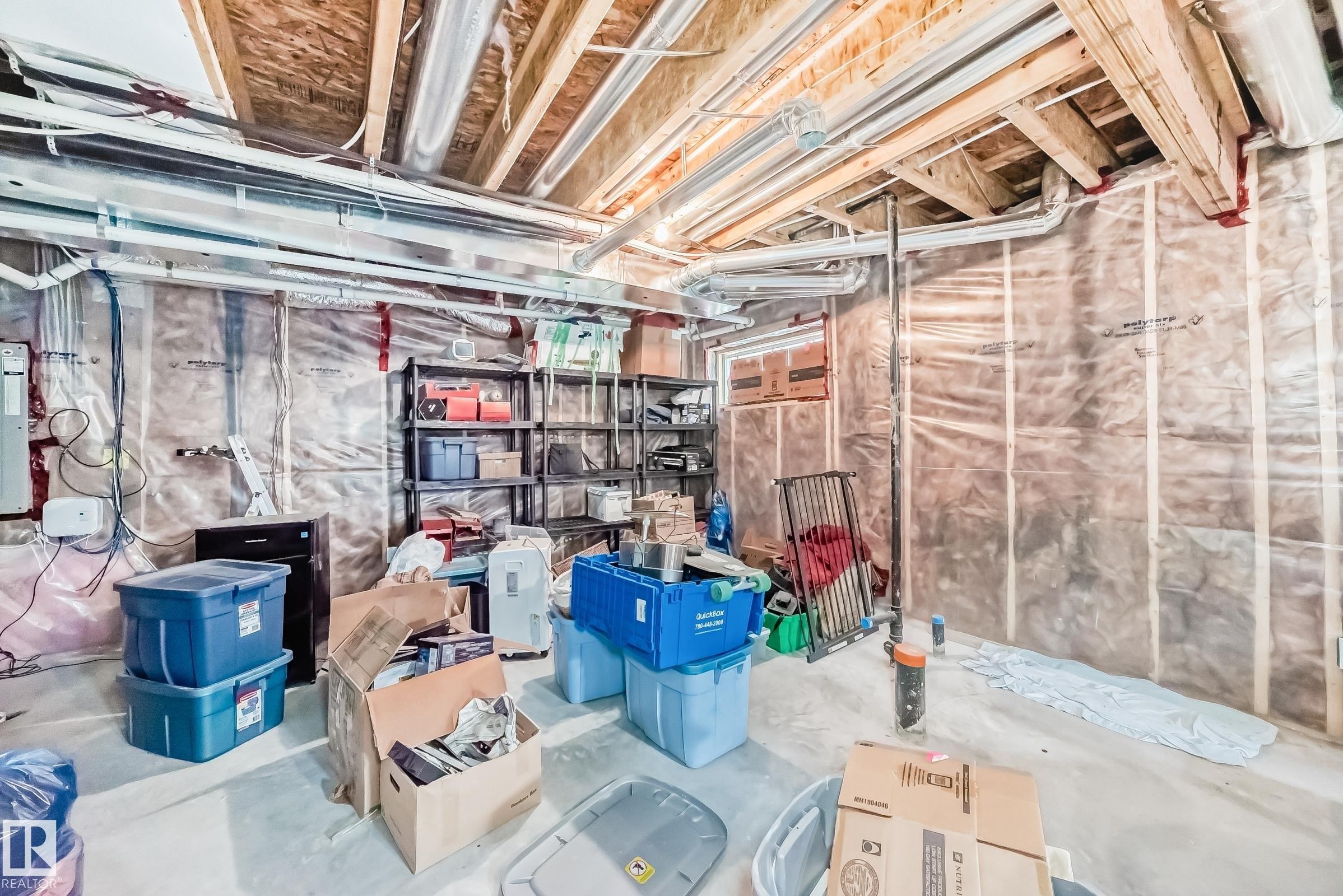 Unfinished basement featuring exposed wood joists, structural piping, a concrete floor, and insulation-lined walls - 10519 114 Avenue, Edmonton, AB - Indoor Photo Showing Basement