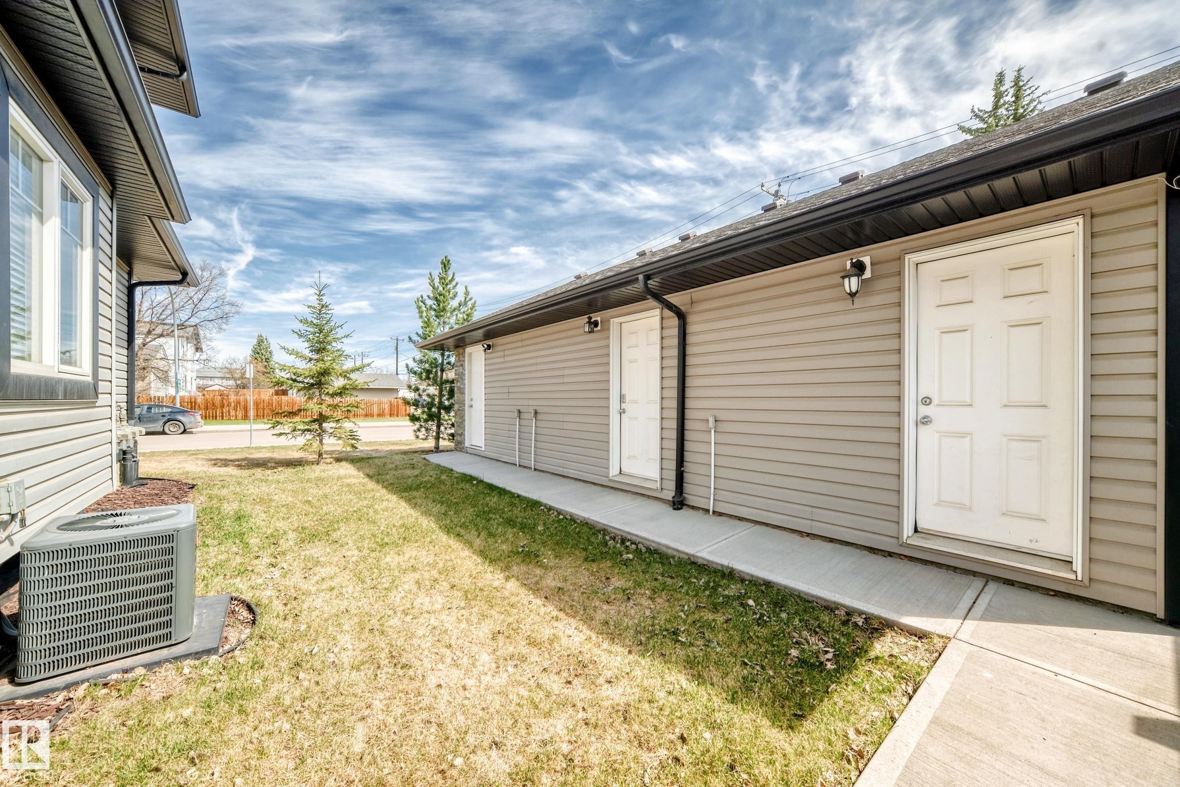 Exterior siding in a neutral tone with two white panel doors and black exterior lighting fixtures - 10519 114 Avenue, Edmonton, AB - Outdoor With Exterior